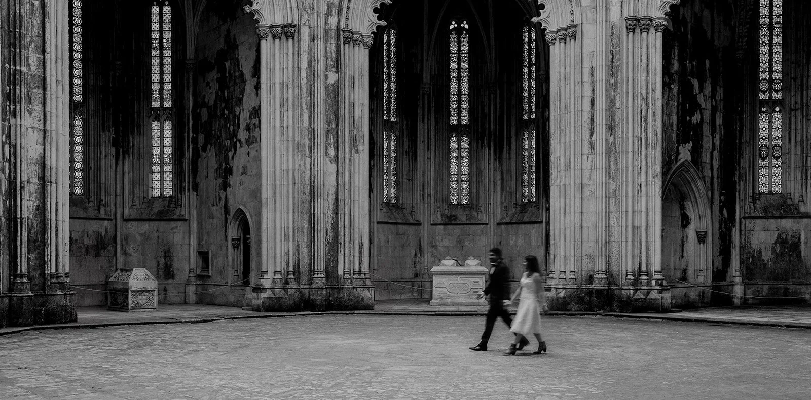 A photograph of the bride and groom walking across an old church in Portugal taken at a wedding by Darius 