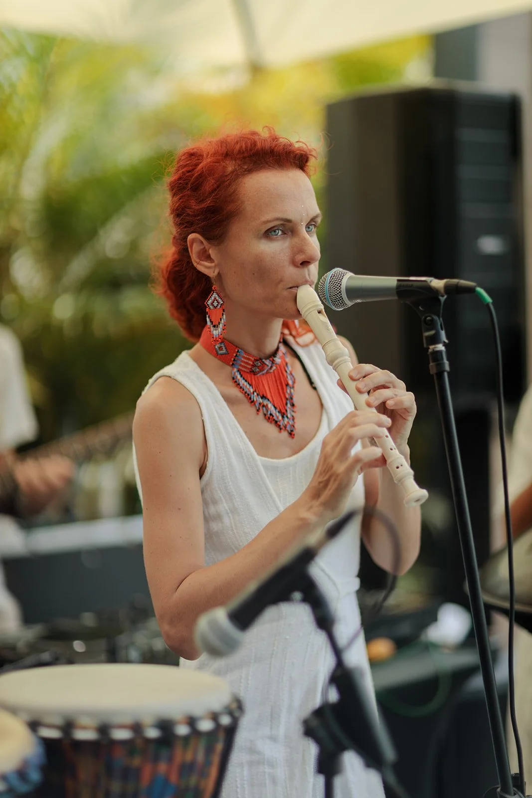 A lady with red hair blowing a flute for an event photographed 