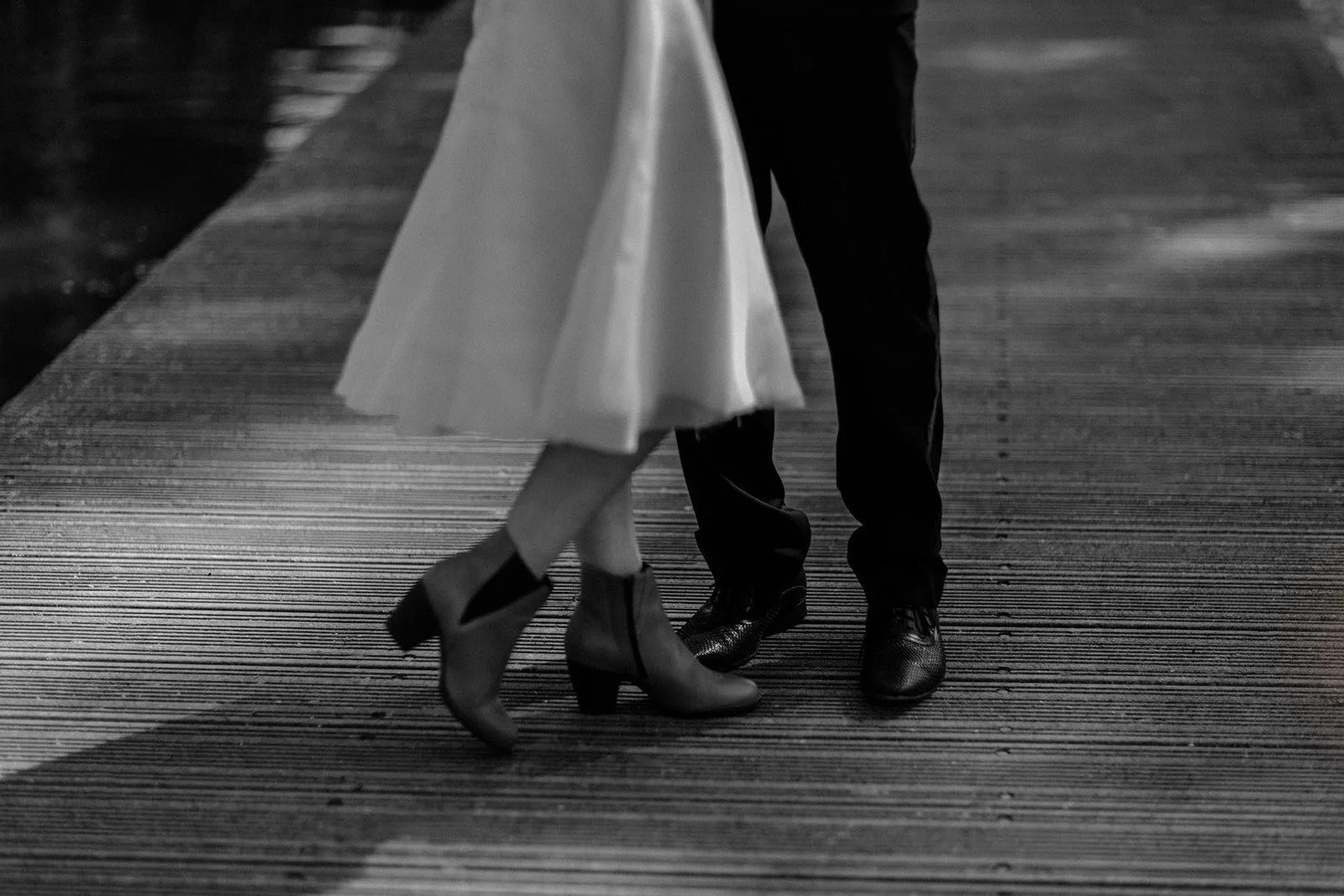 A close up black and white photograph of a couples legs as they are close to each other in Groningen, Netherlands