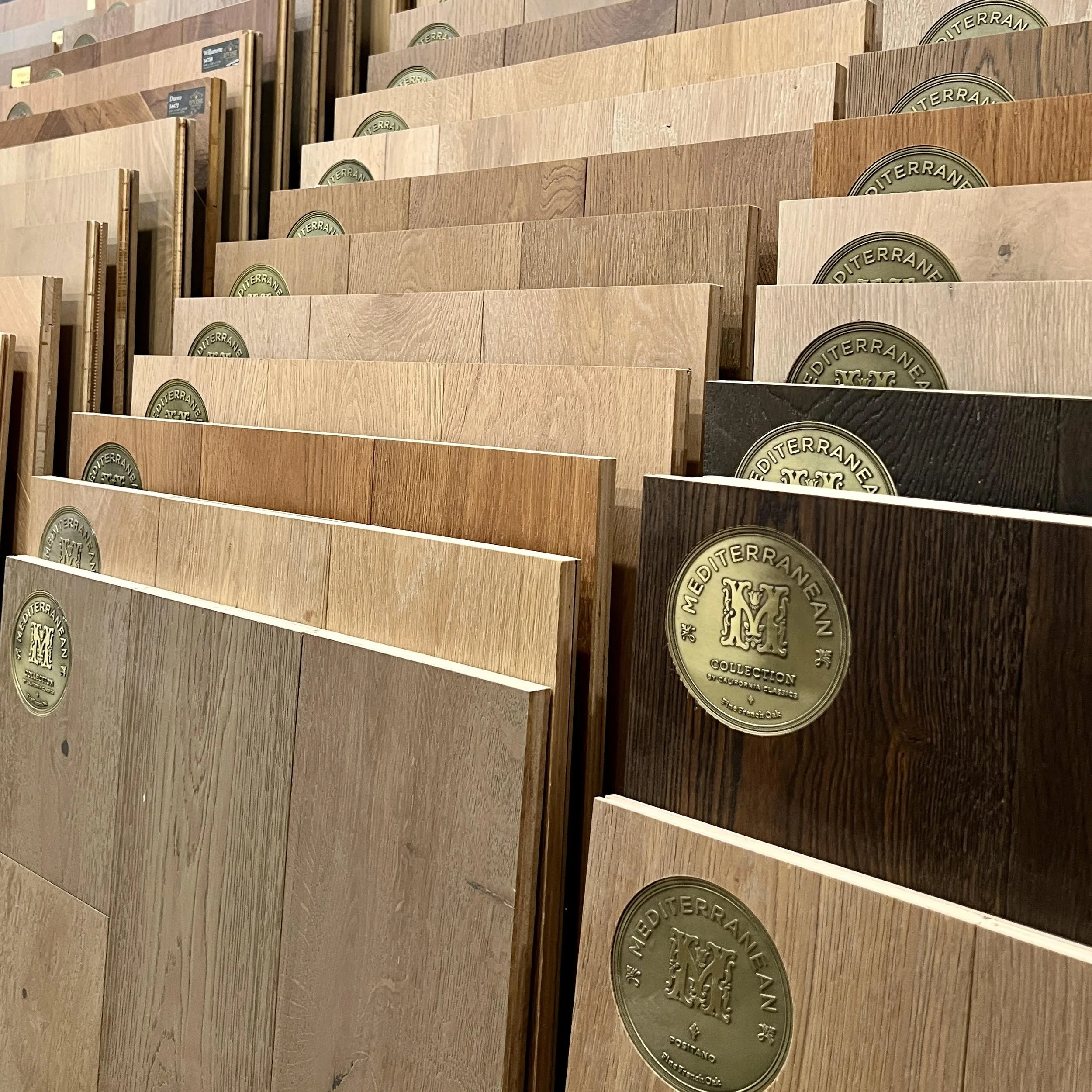 Display of various engineered hardwood flooring samples including Divine and Mediterranean Flooring by California Classics Floors.
