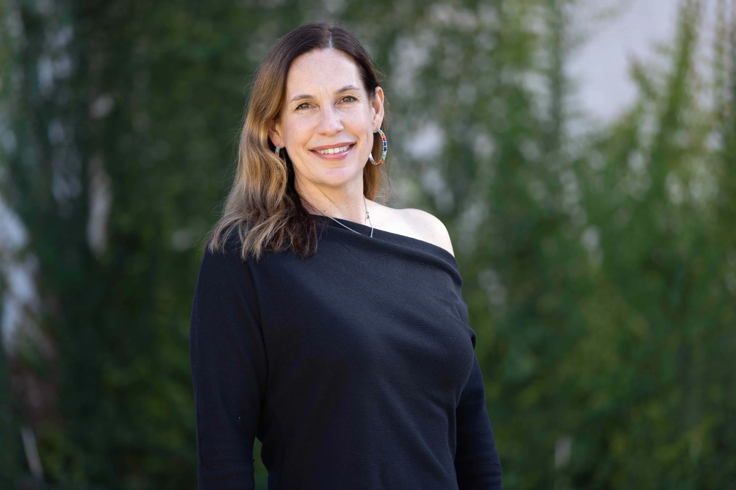 Paula Nelms, smiling and wearing a black top, upper body portrait of a functional medicine nutritionist