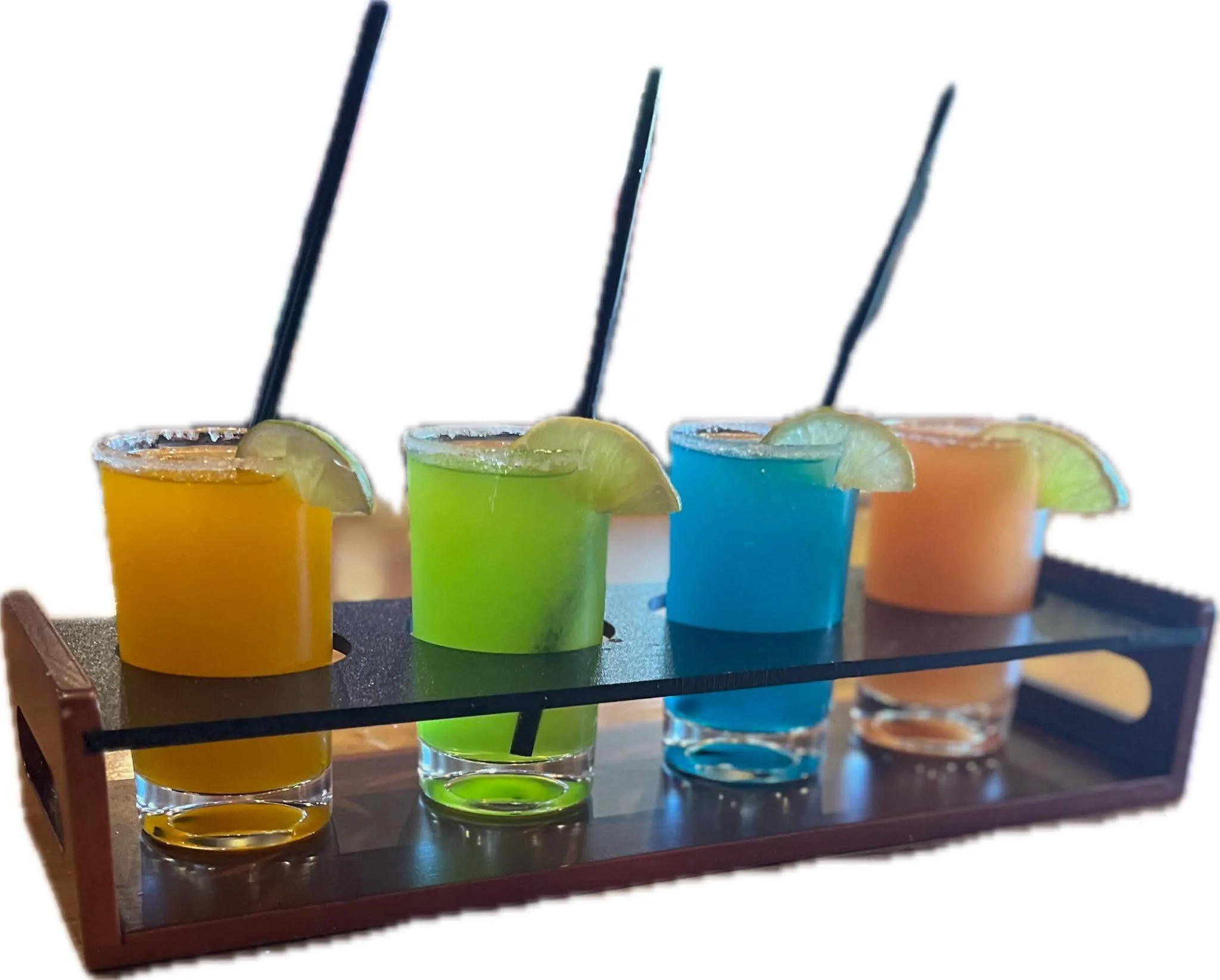 Four colorful cocktails on a wooden tray, each garnished with a lime wedge and a black straw, with salted rims.