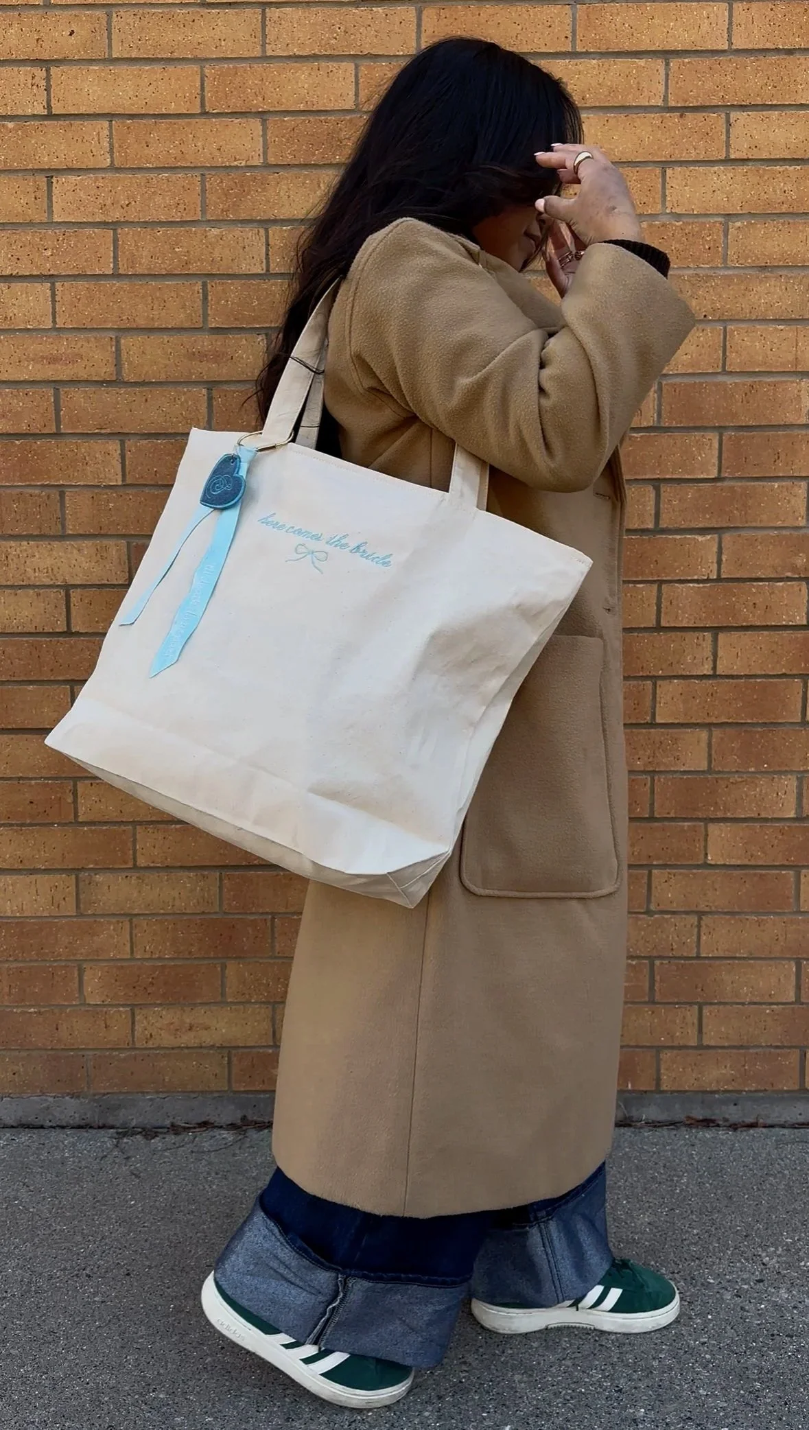 Close-up of embroidered bow and ‘Here Comes the Bride’ text on personalized canvas bridal tote bag