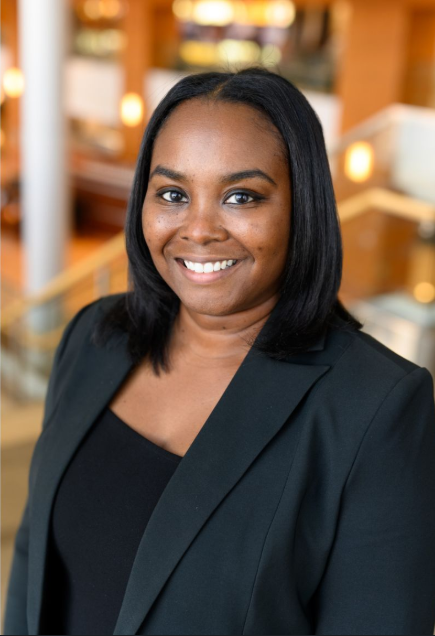 Professional woman smiling in an office or corporate setting.