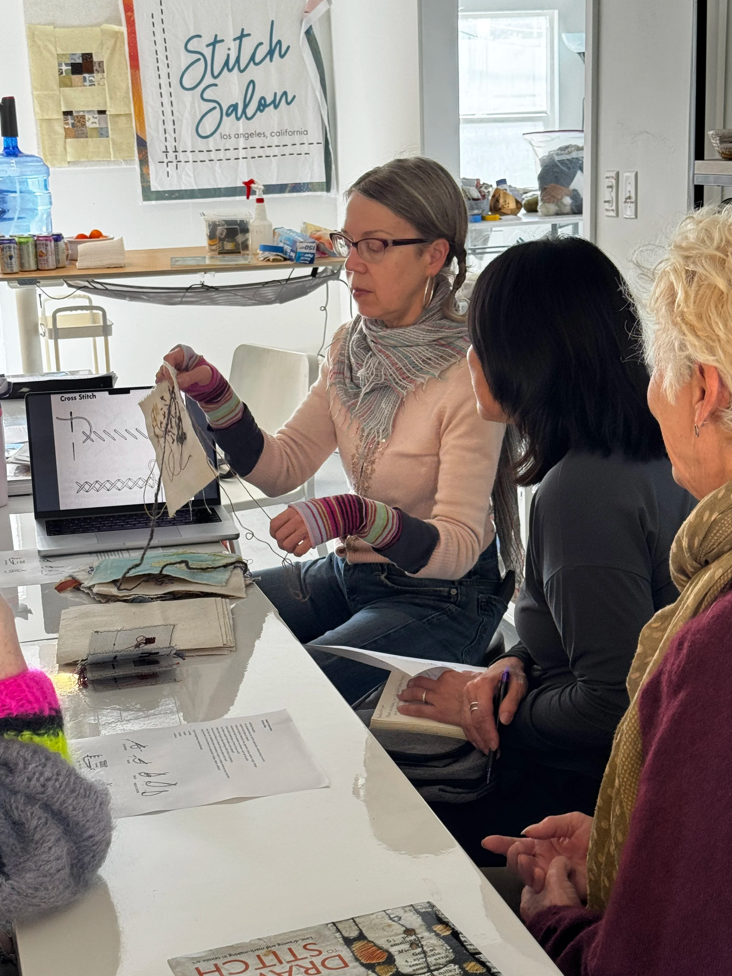 sewing teacher victoria may teaches a diverse group of women hand stitching techniques