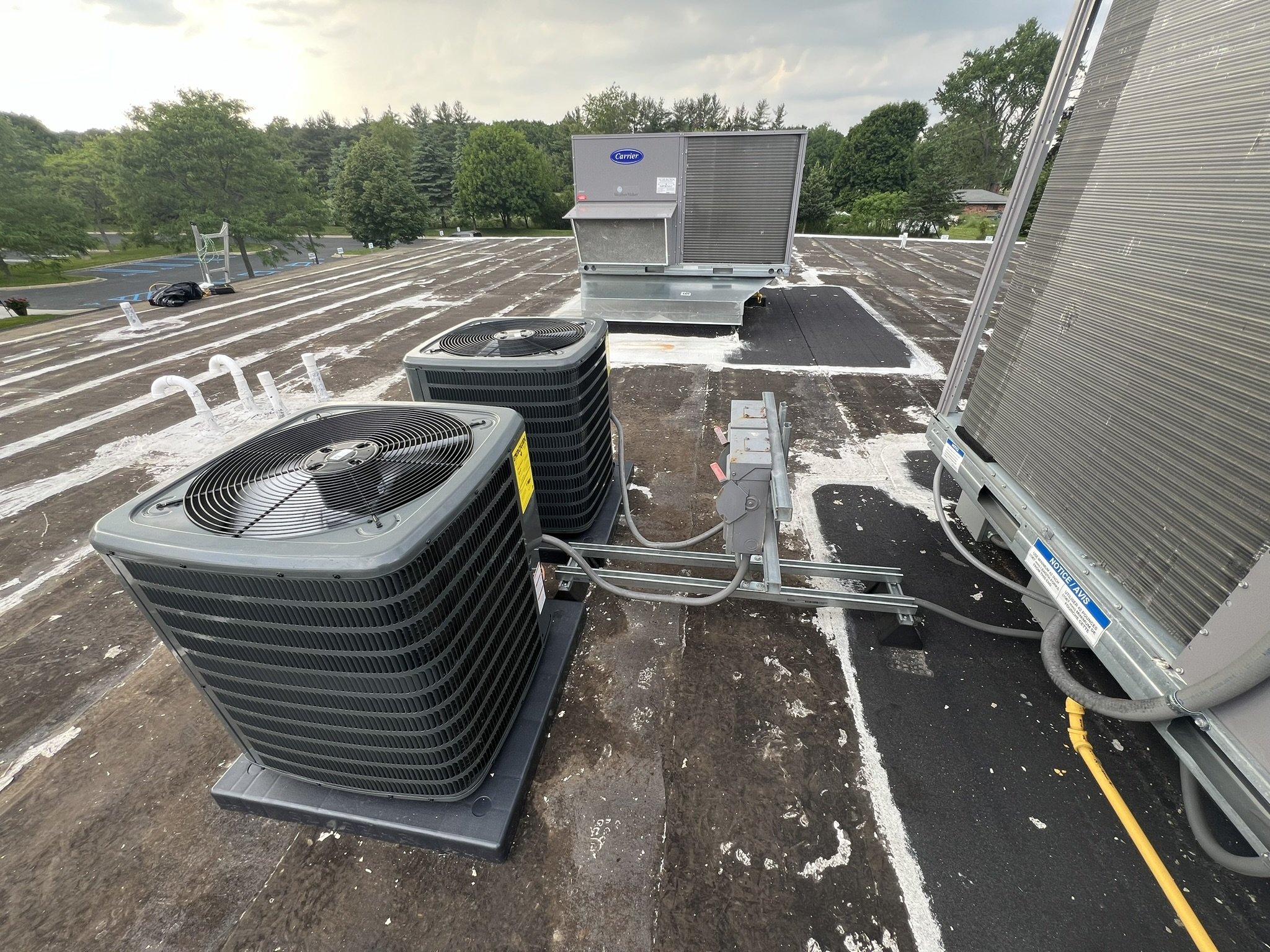 Rooftop HVAC units and air conditioning condensers on a commercial building roof.