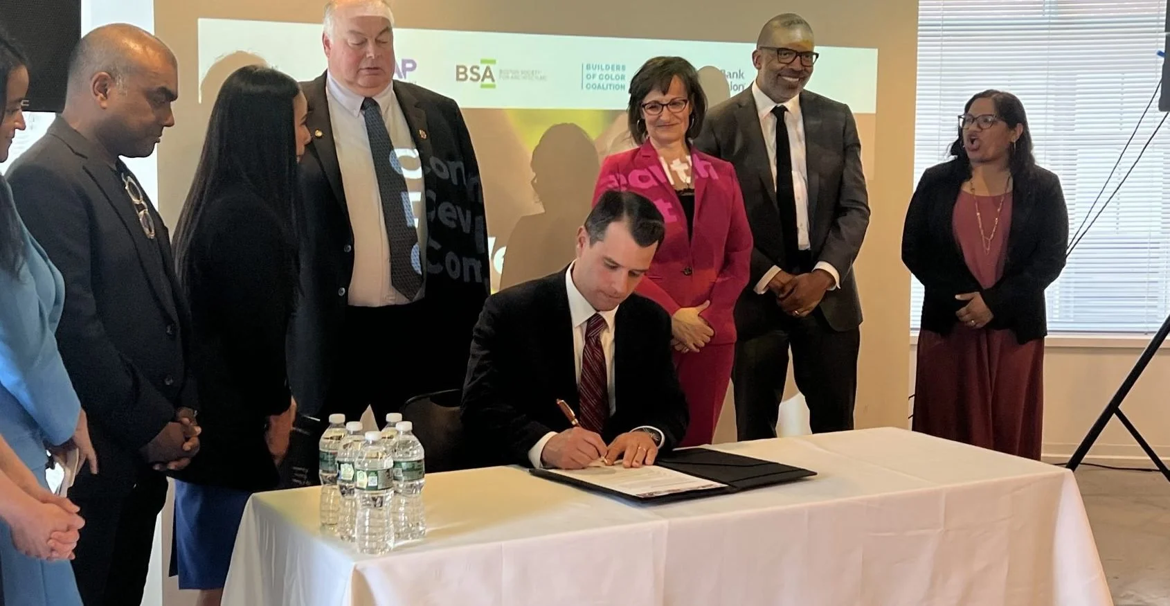 Mayor Jared Nicholson signs the “Commonwealth Development Compact” on Monday. (Emily Pauls )