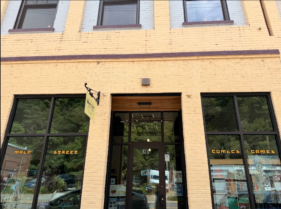 Front view of a brick building with large windows, sign reading 'CONLEC GAMES' and 'NAIL STREET' on the windows, and an entrance door with an 'OPEN' sign.
