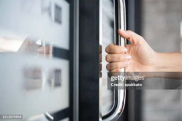 Person pulling a contactless credit card or debit card from an ATM machine.