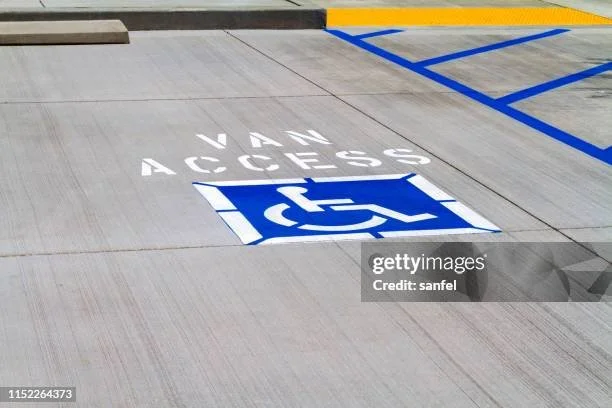 Parking space with a white 'Van Access' marking and a blue handicap accessible symbol on the ground.