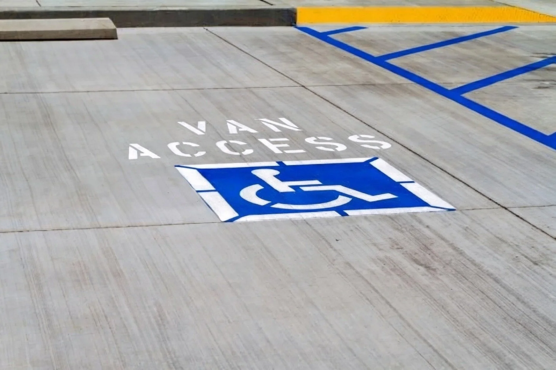 Parking space with a white 'Van Access' marking and a blue handicap accessible symbol on the ground.
