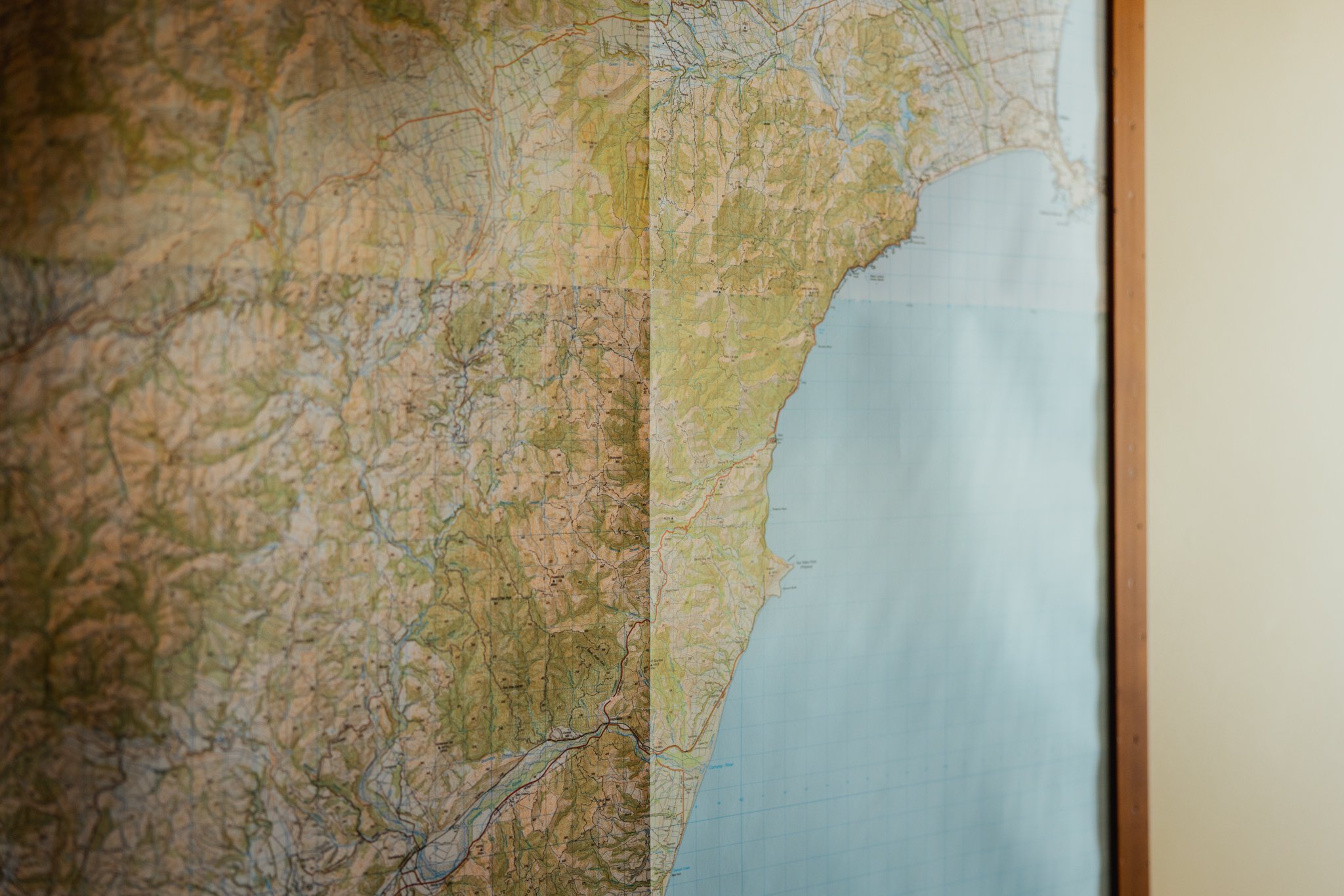 Close-up of a detailed map on a wall, showing various geographical features and markings.