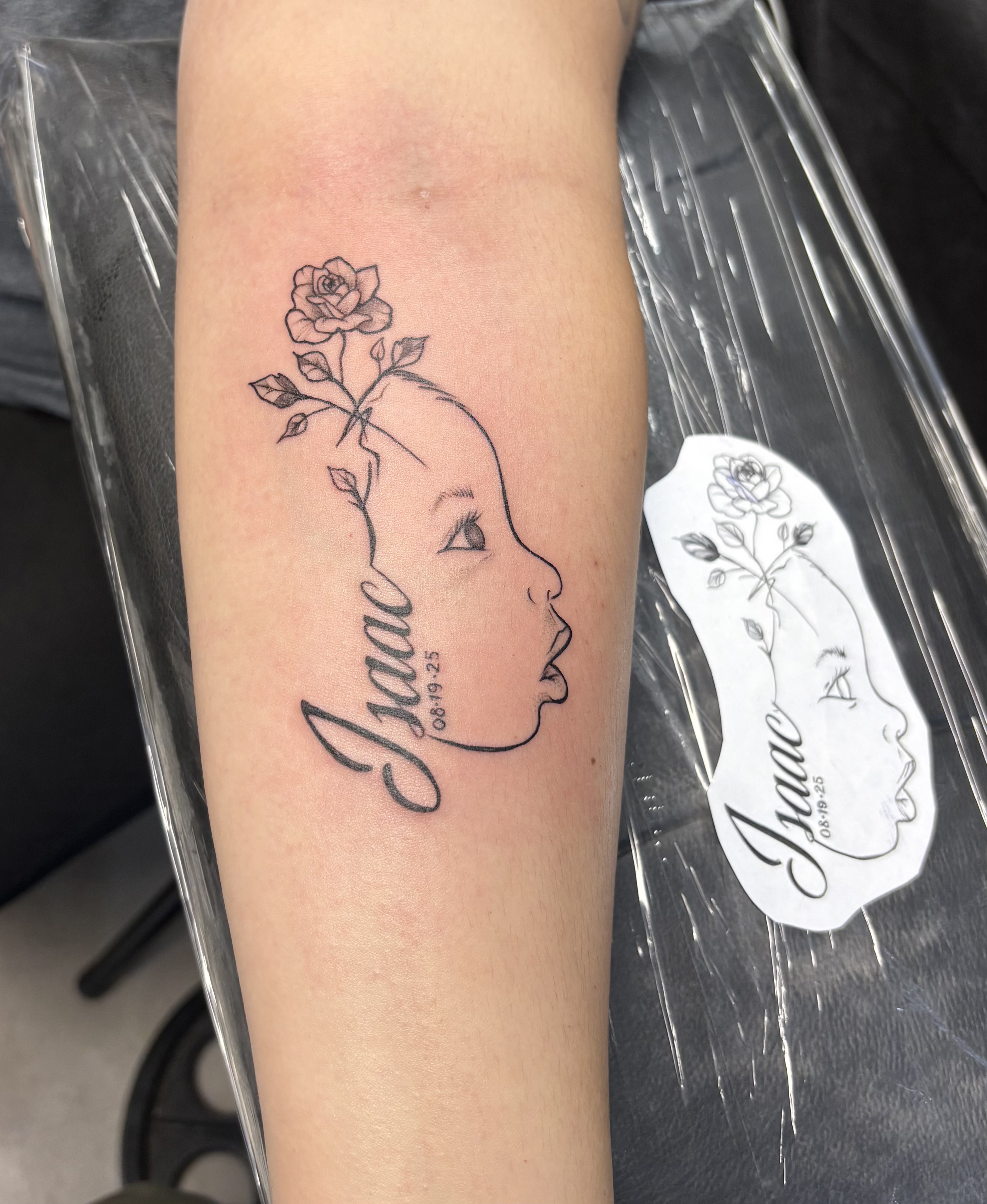 Tattoo of a girl's profile with a rose growing from her head, the name 'Jane' and a date '06-19-25' below the name.