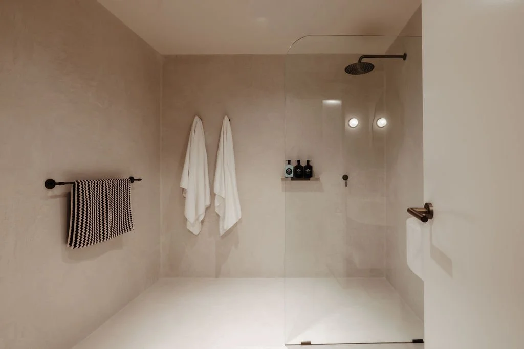 Minimalist walk-in shower at Sola Studios Margaret River featuring stone finishes, boutique amenities and calming interiors designed for slower stays.