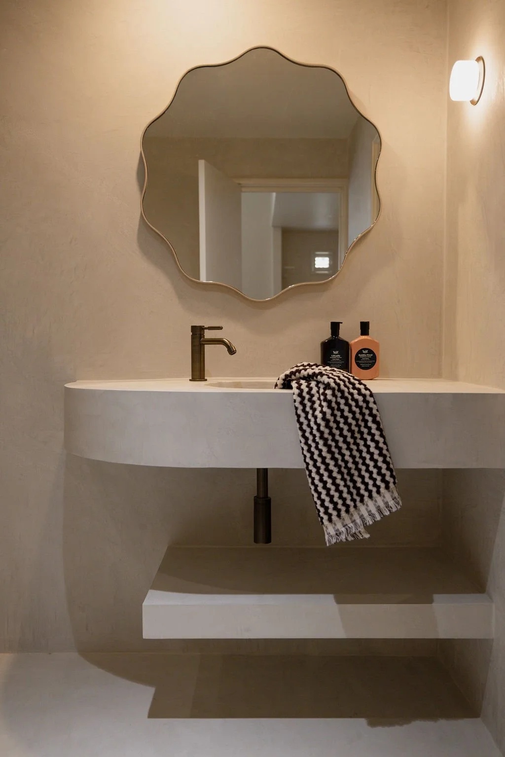 Minimalist bathroom at Sola Studios Margaret River featuring bespoke mirror, stone vanity and refined boutique finishes inspired by slower luxury stays.