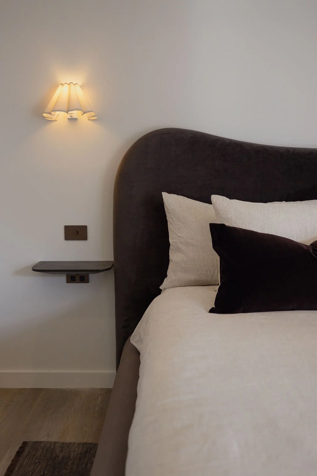 Boutique bedroom at Sola Studios Margaret River featuring sculptural upholstered headboard, premium linens and warm minimalist design for slower stays.