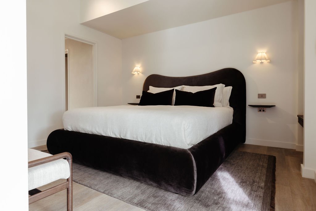Spacious boutique bedroom at Sola Studios Margaret River with oversized upholstered bed, luxury finishes and warm minimalist interiors.