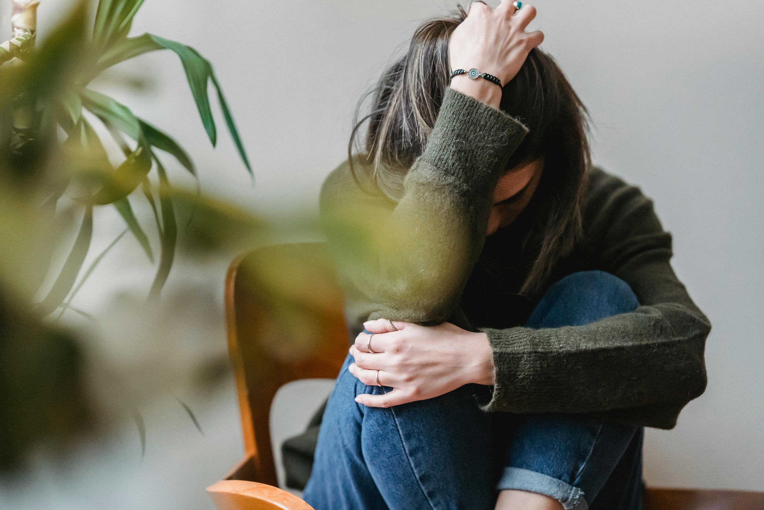Woman with her face in her knees looking stressed