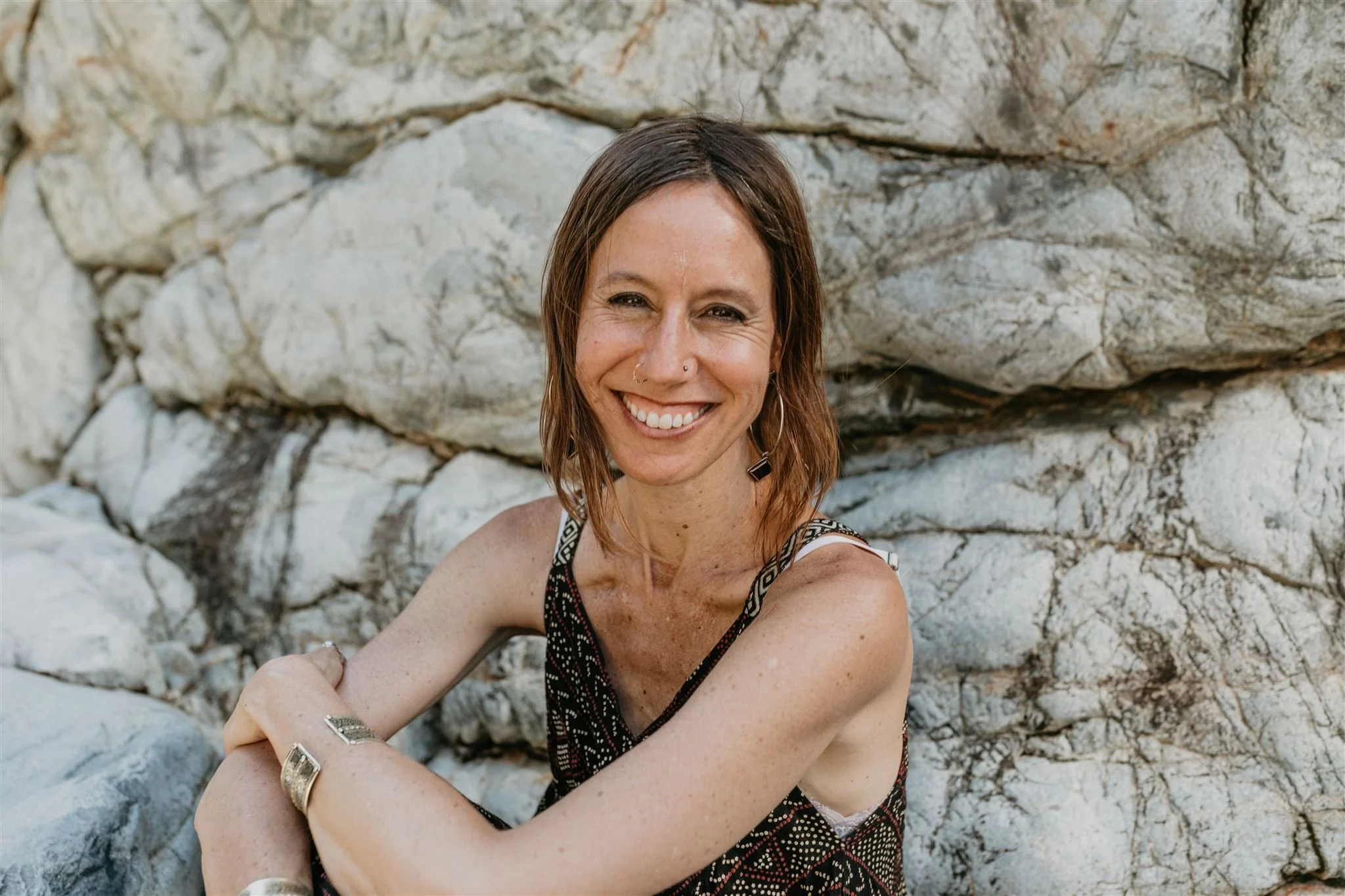 Chandra, holistic vitality coach, outdoors smiling at the camera
