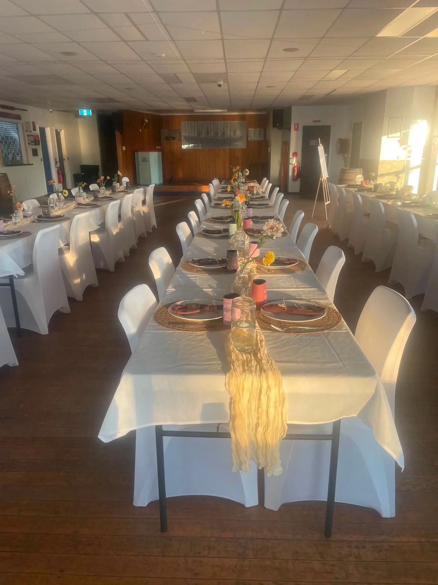 A view of the function room set-up for a wedding showing three rows of tables comfortably sitting 60 guests.