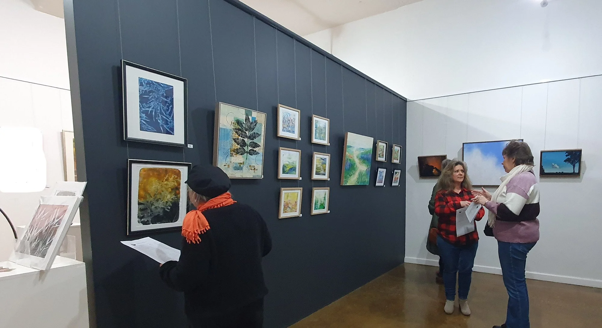 Exhibition Opening night showing people looking at Gelprint artworks