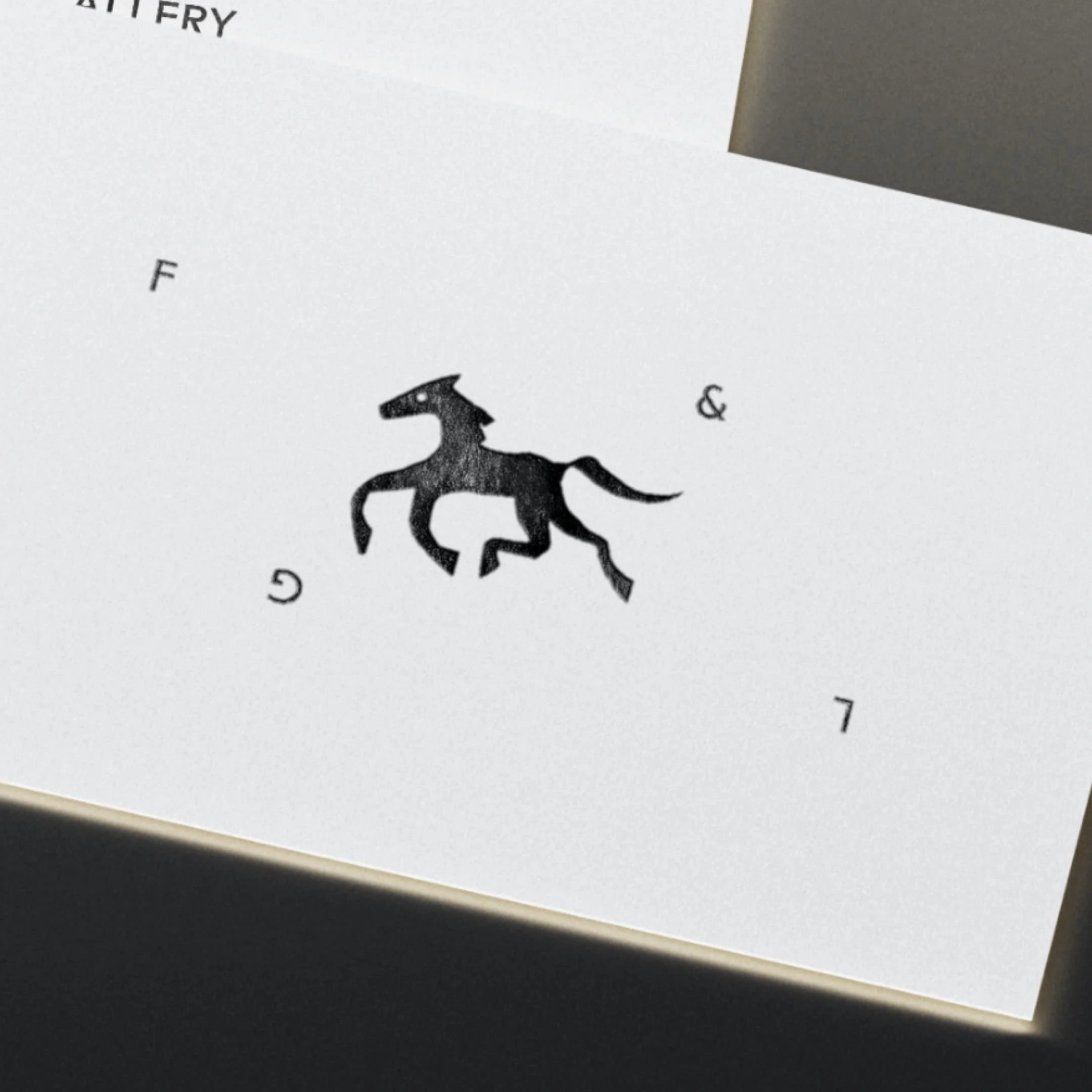 Close-up of a map with a black silhouette of a fox positioned centrally, surrounded by scattered letters 'F,' 'T' and '&' on a white background.