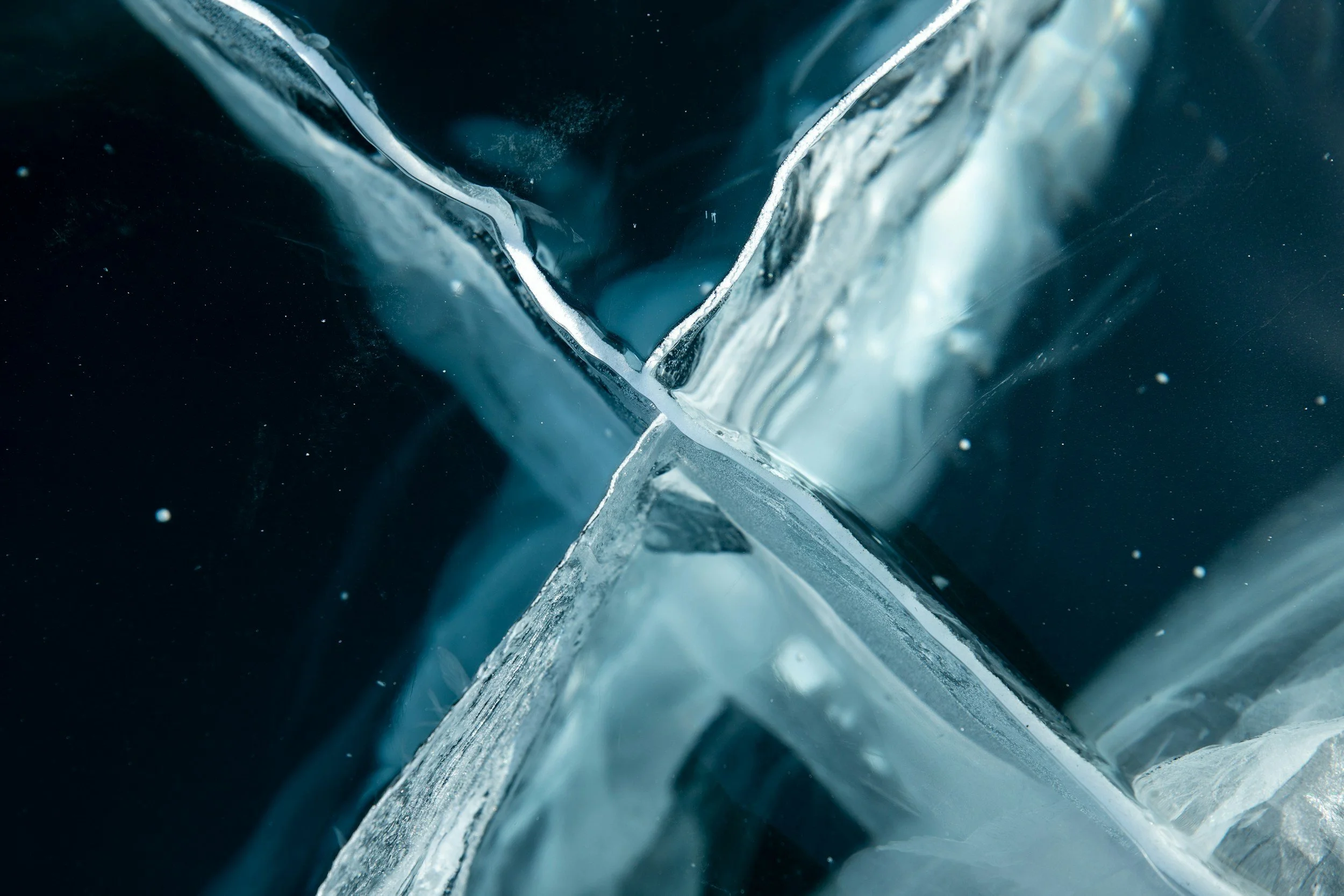 Close-up image of blue ice cracks and transparent ice formations.