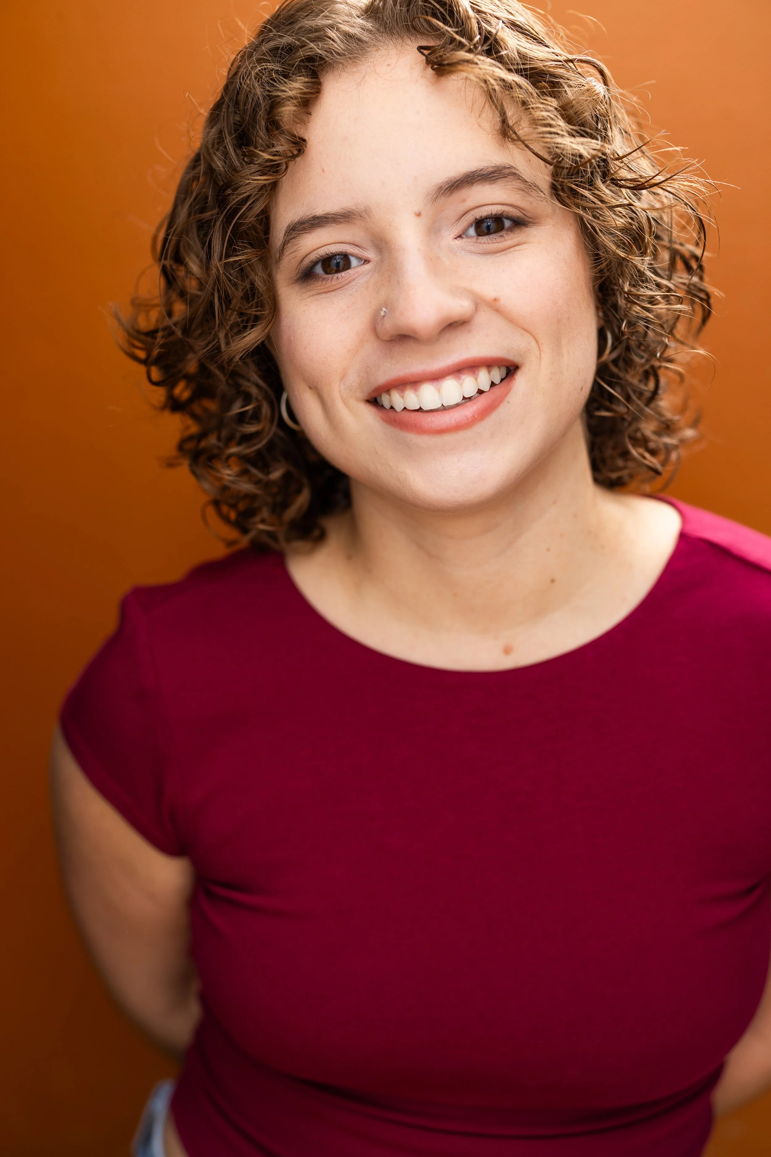 Eva Luna Cirilo commercial headshot smiling in cherry top. 