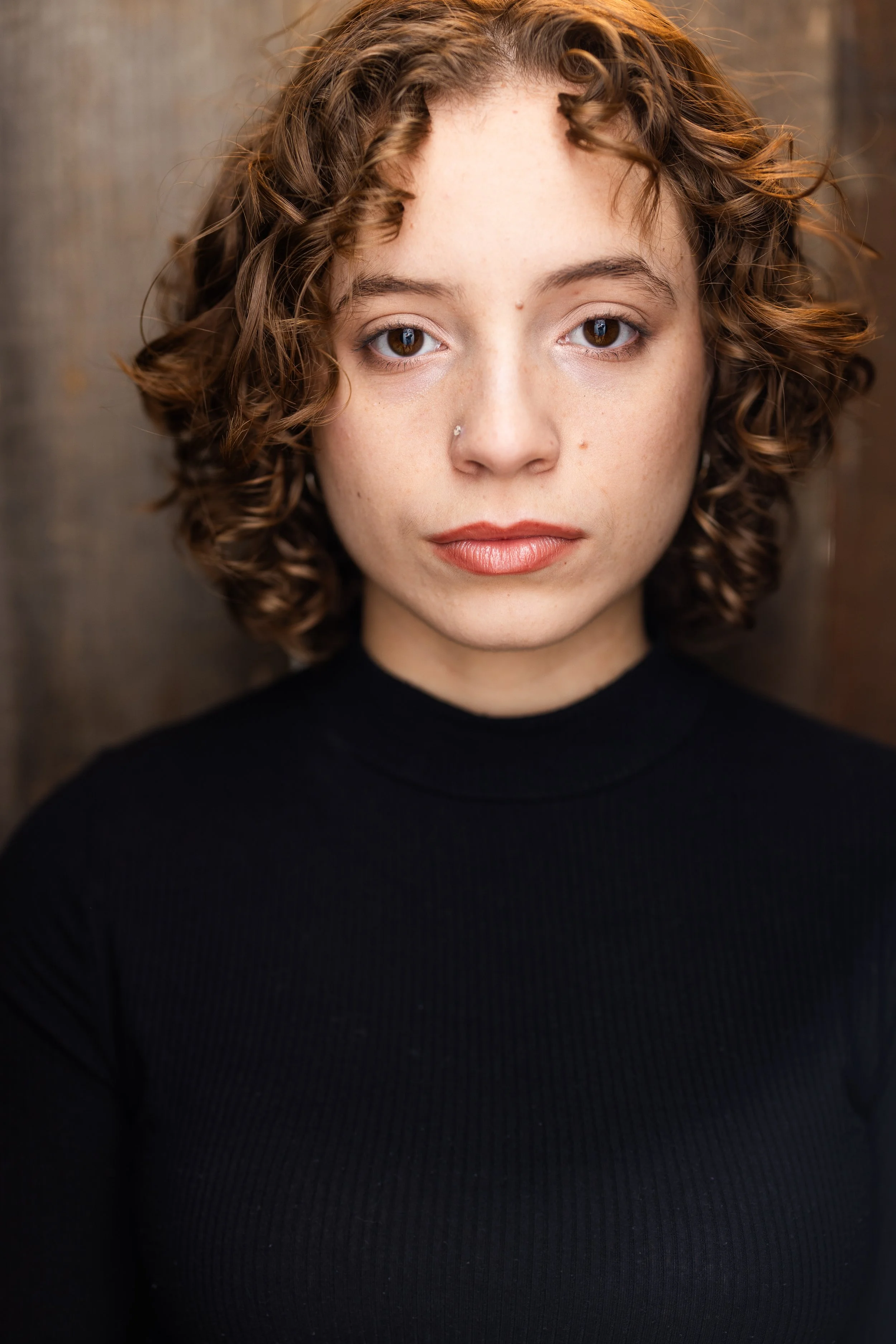 Eva Luna Cirilo serious theatrical actor headshot in black turtleneck.