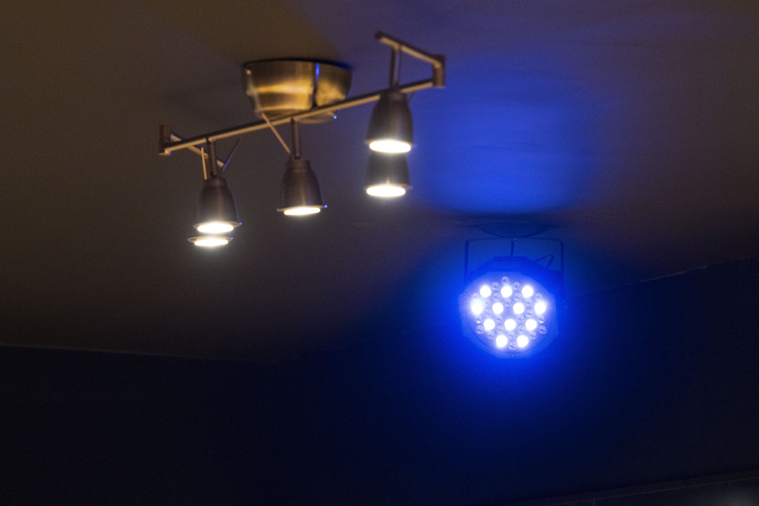 Ceiling with multiple lighting fixtures, including aesthetic spotlights and a multicoloured LED light.