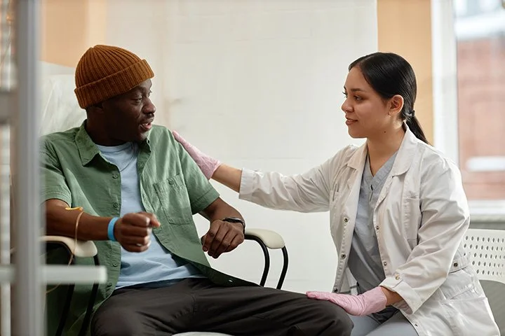 A nurse comforting a patient in a hospital room.