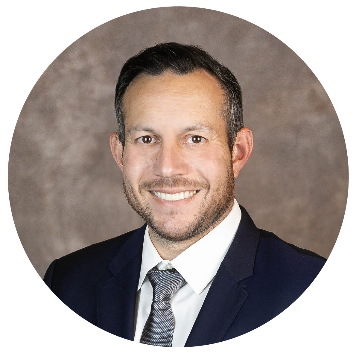 Professional portrait of a smiling man in a dark suit, white shirt, and gray tie, against a neutral background.