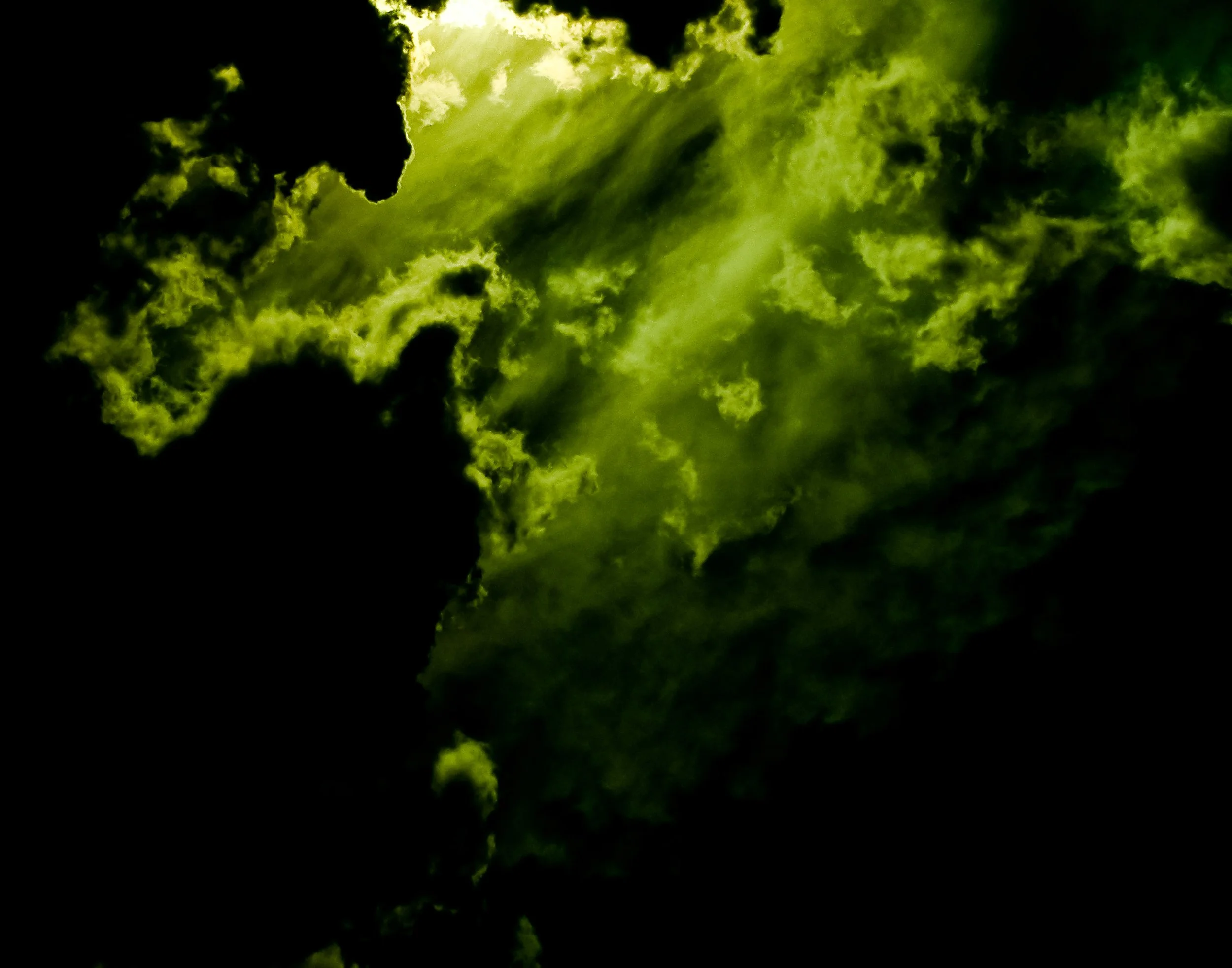Dark clouds with bright greenish-yellow highlights, creating a dramatic sky scene.