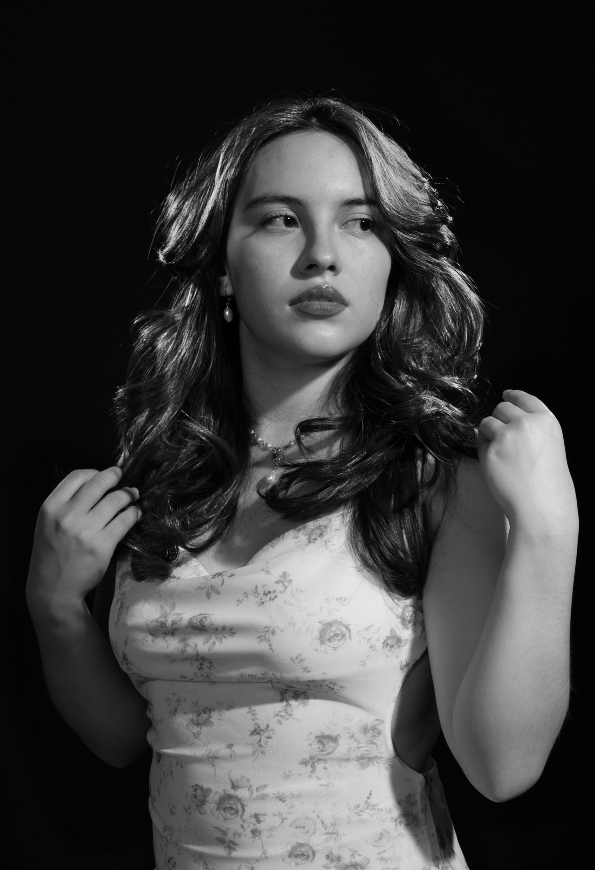 Dramatic black and white editorial portrait of Jissel using chiaroscuro lighting in a Toronto photo studio.