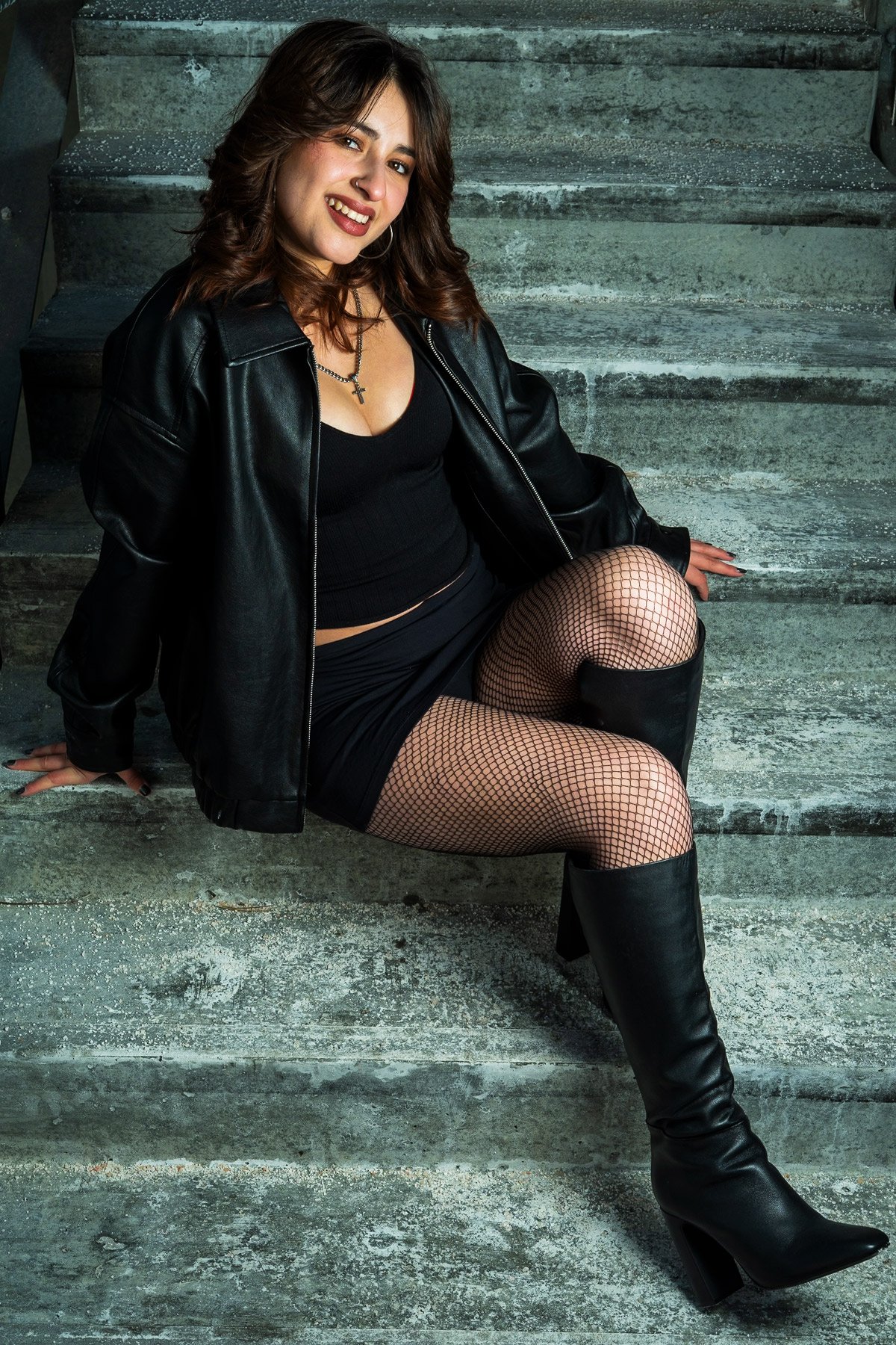 Ariz smiling and leaning against concrete stairs during a portrait session in Etobicoke, Toronto.