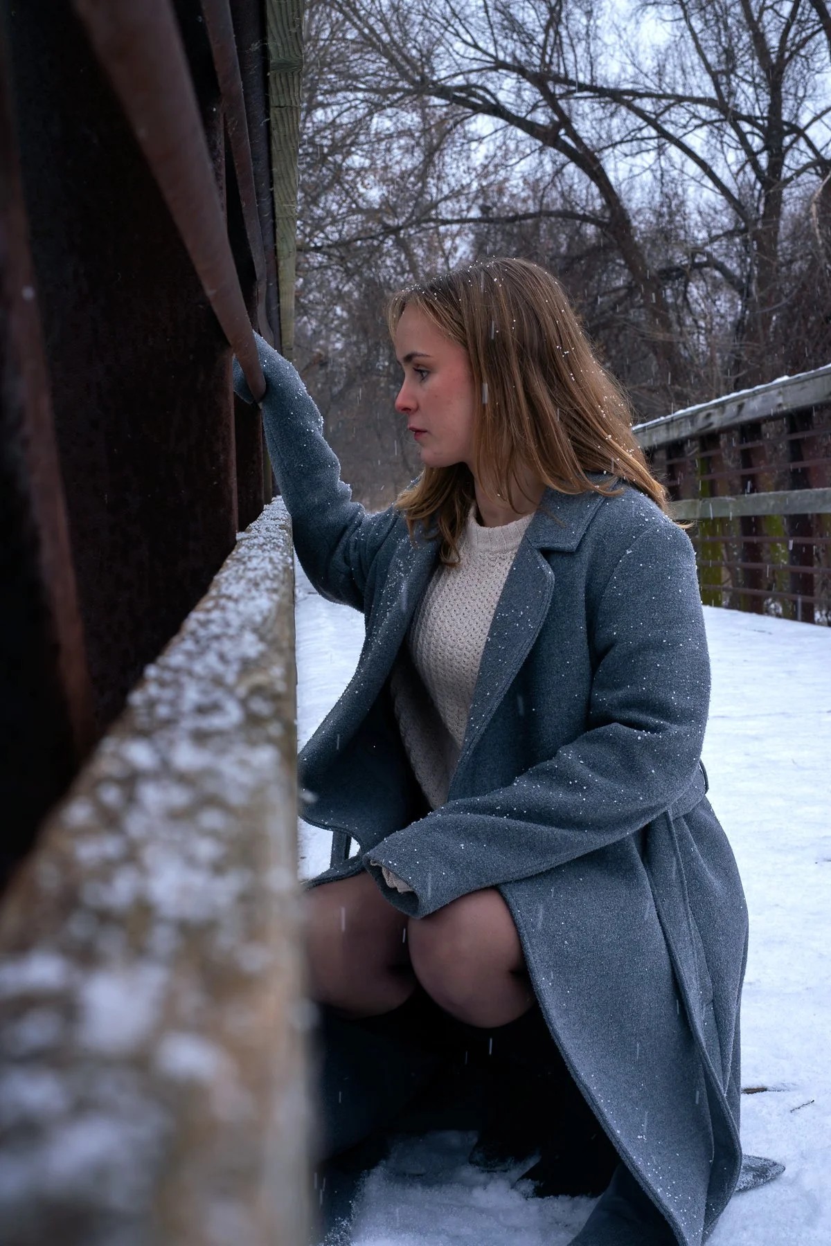 Guelph-Humber student Abigail Flipsen leaning against a railing during an outdoor winter photoshoot in Toronto.