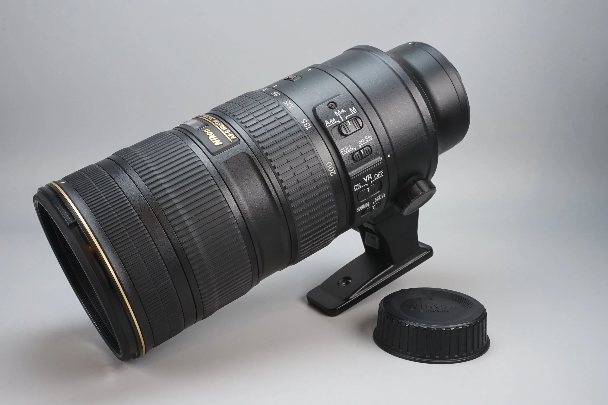大型のニコンのズームレンズとレンズキャップ