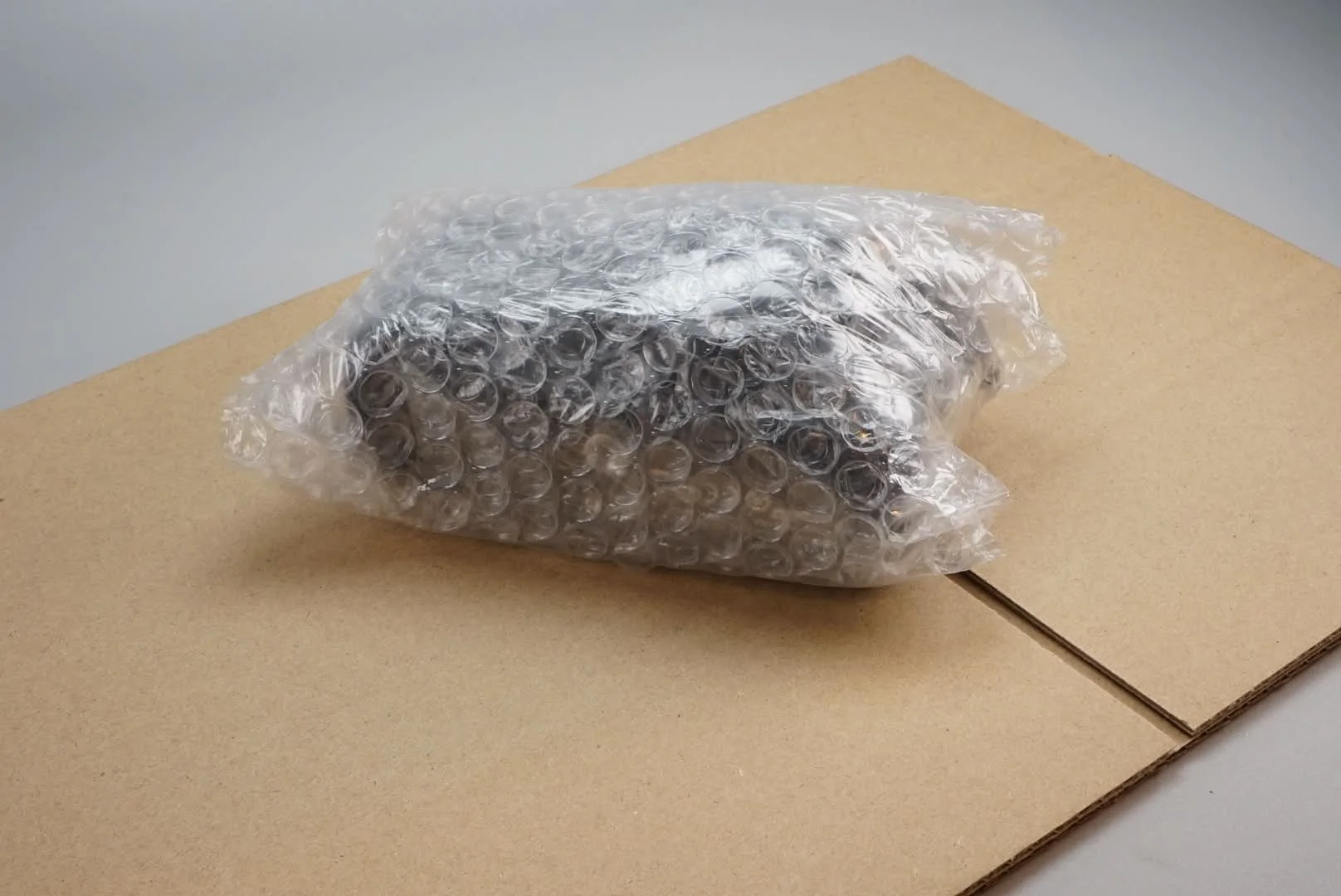 段ボール板の上にビニール袋に入った電子機器が置かれている写真