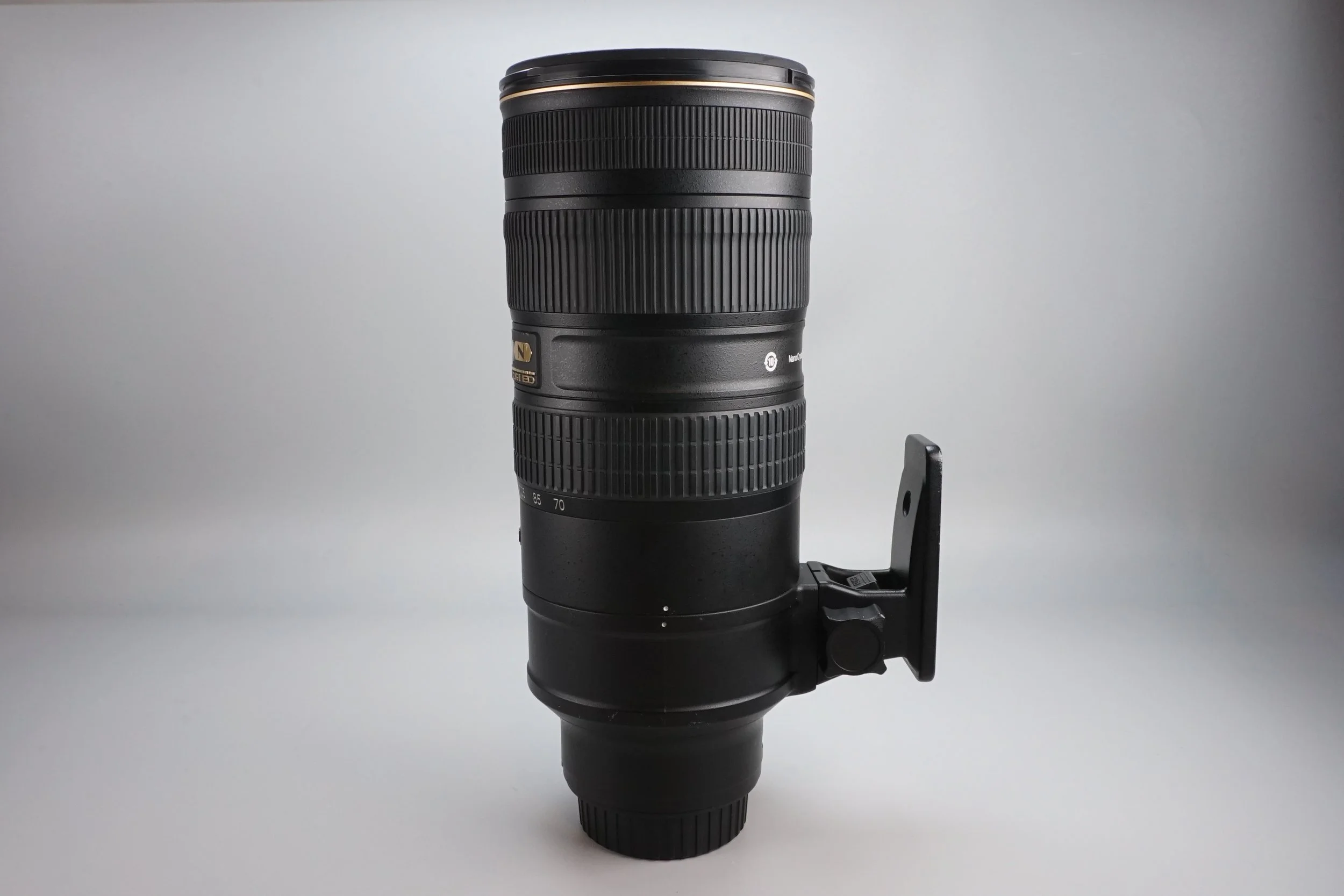 長いズームレンズのカメラレンズが縦向きに立てられている写真。