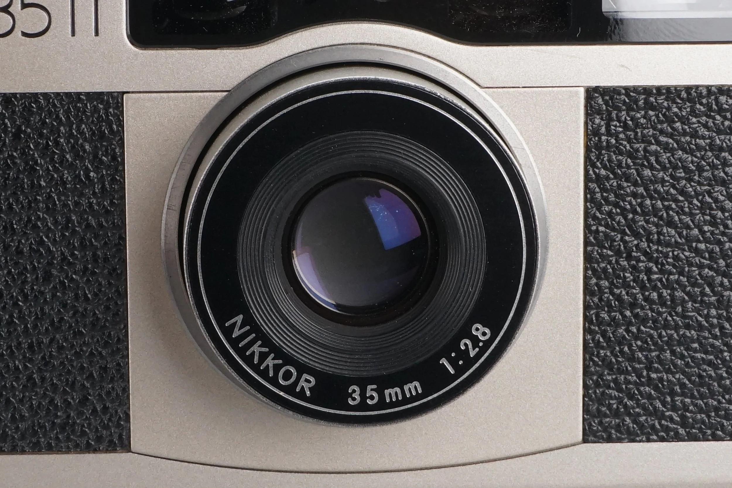 ニコンの35mmレンズを搭載したカメラのレンズ部分、焦点距離1:2.8と書かれている