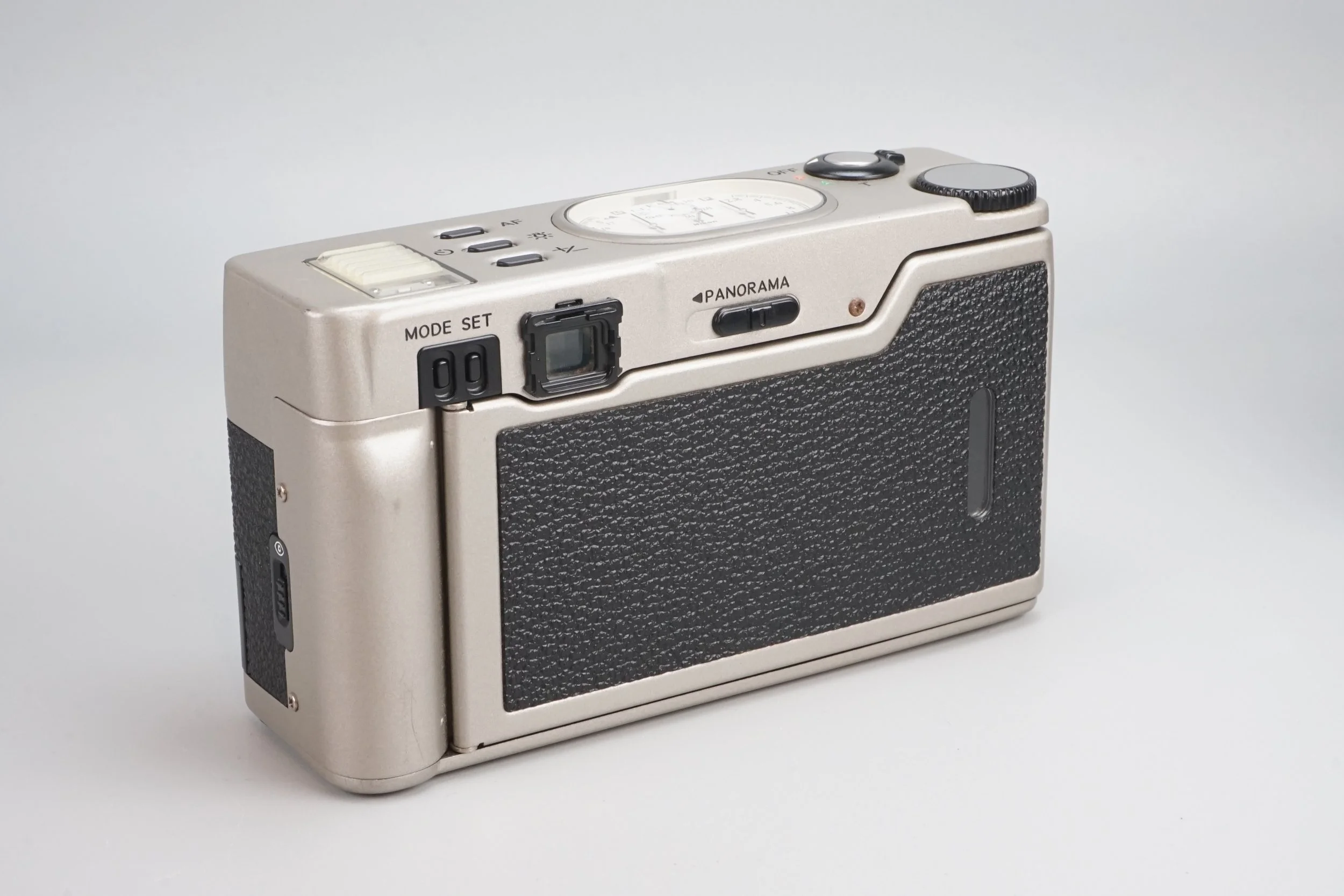 白と黒のデジタルカメラ。背面に液晶画面といくつかのボタンがある。