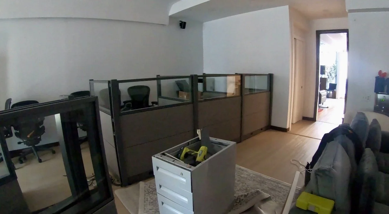 Office with cubicles, chairs, and a space with a box containing tools.
