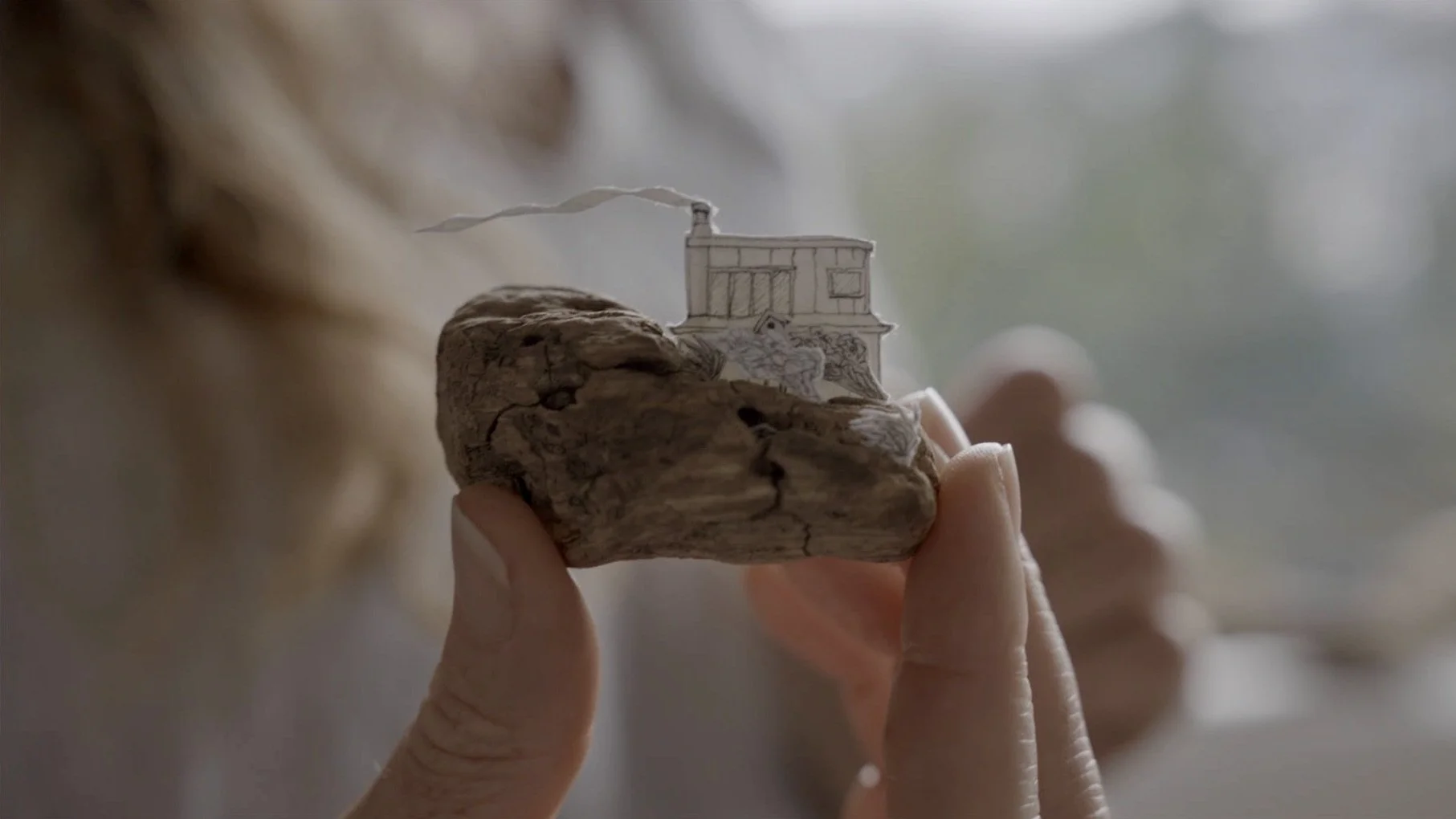 Image from an Art of Making film: a pencil-drawn house on driftwood by Miriam Tong