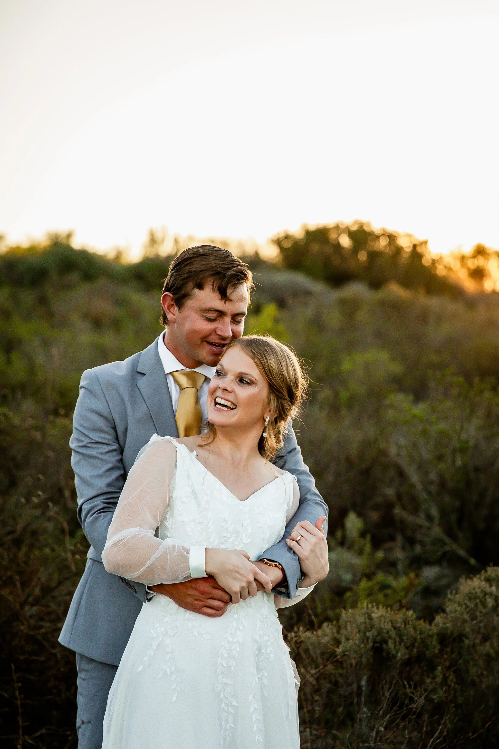 Laurie’s customers, Fernando and Kate embracing by the lake on their wedding day.