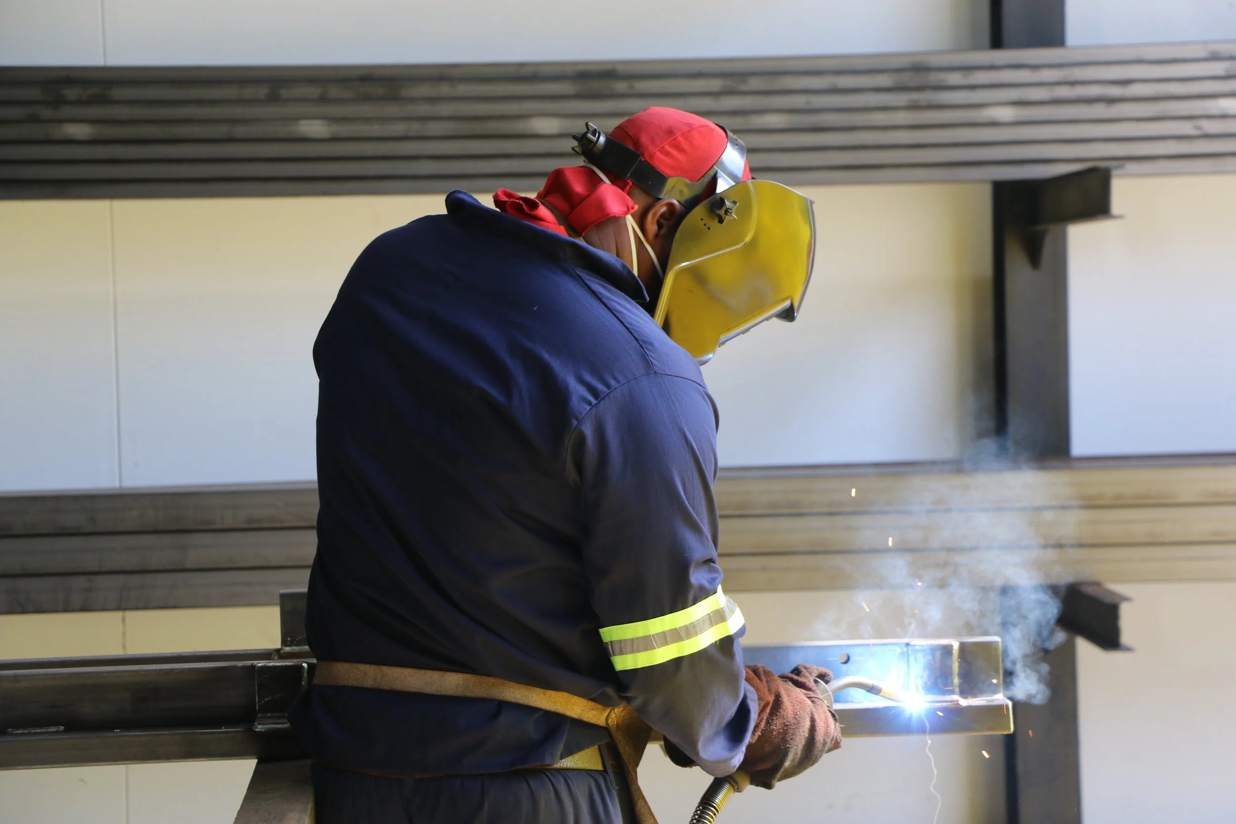 A person in safety gear welding steel for a padel court.