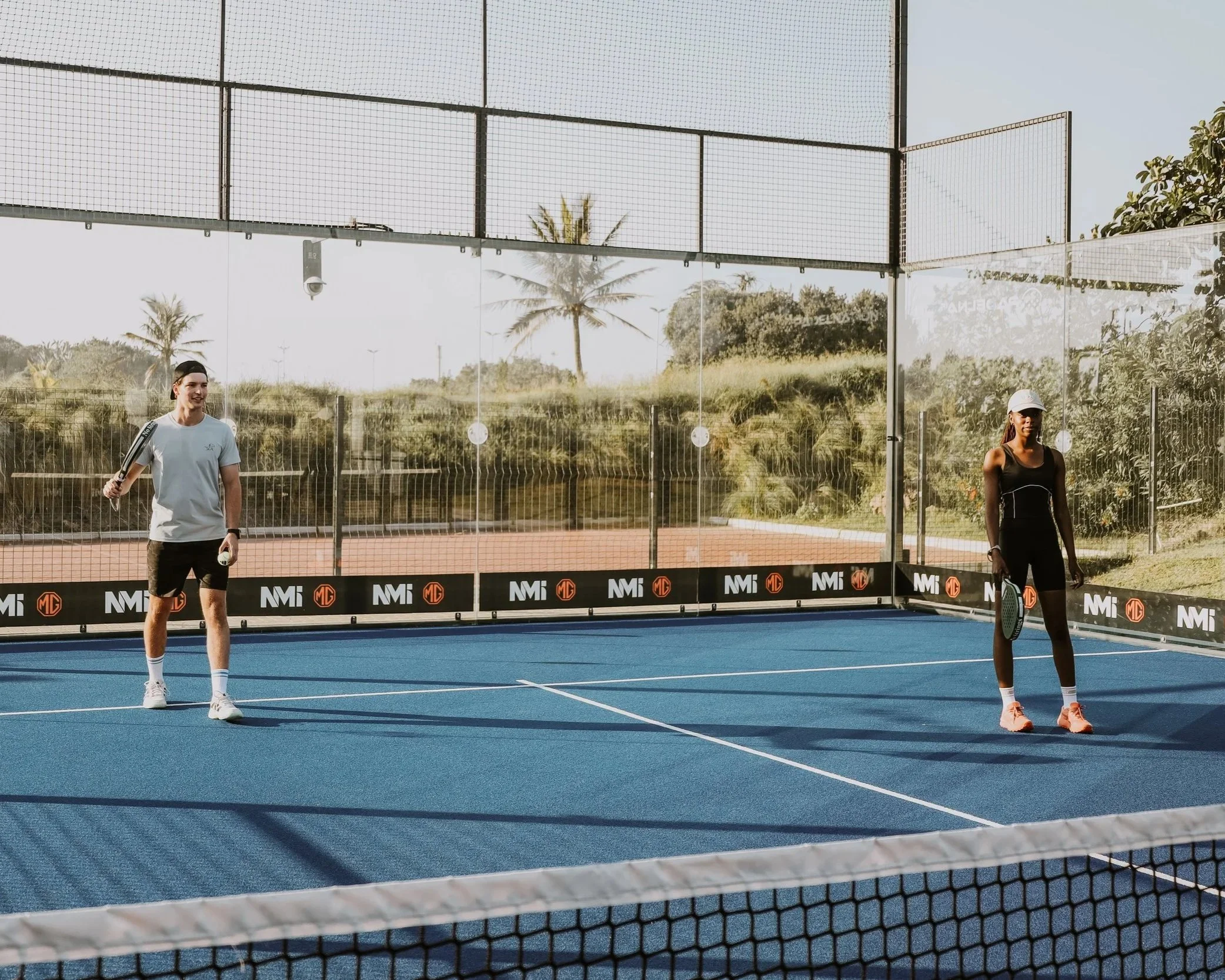 Two padel players on the Durban Country Club Padel court, playing padel.