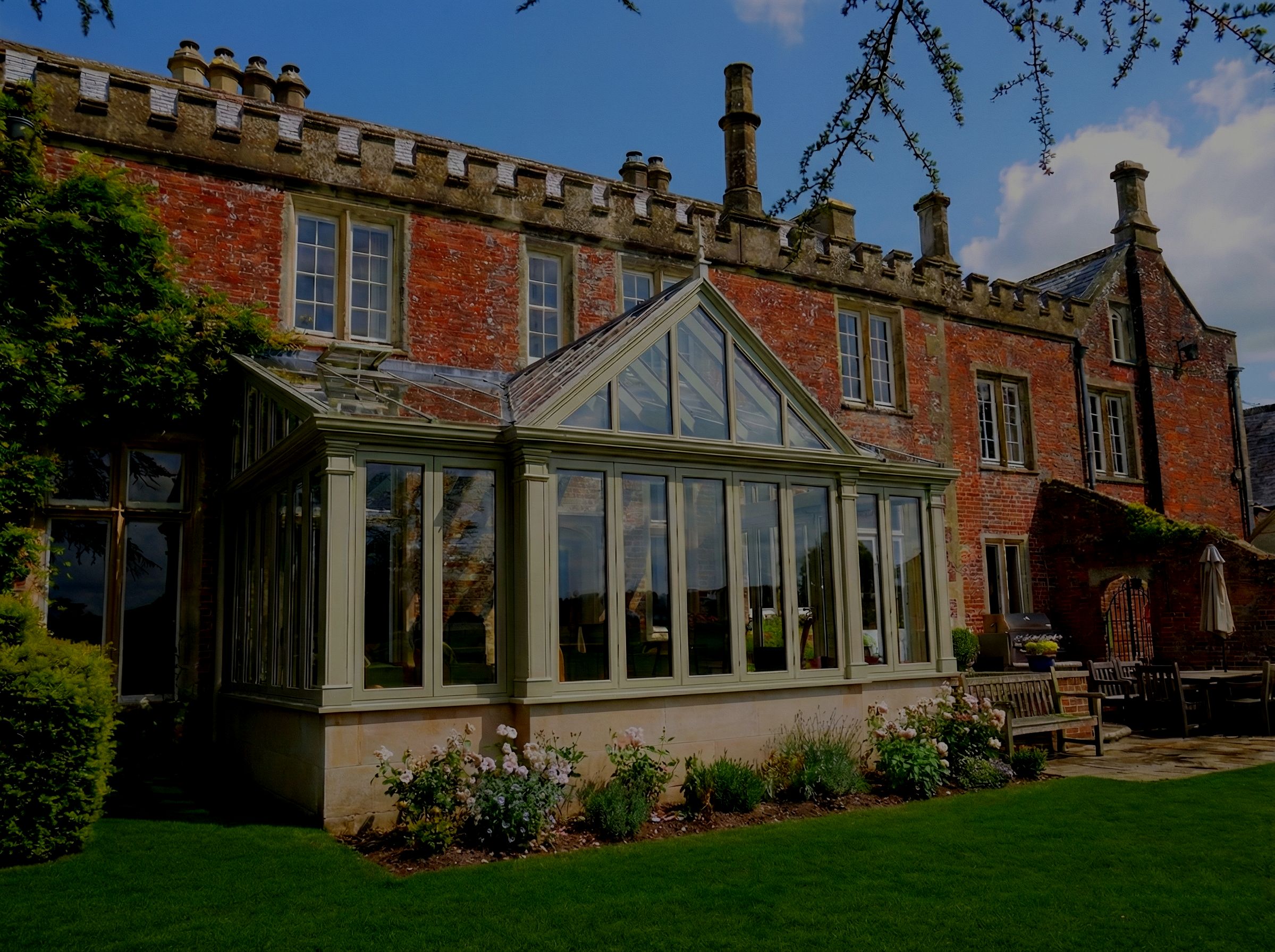 Historic and substantial redbrick home with modern hardwood conservatory extension painted sage green
