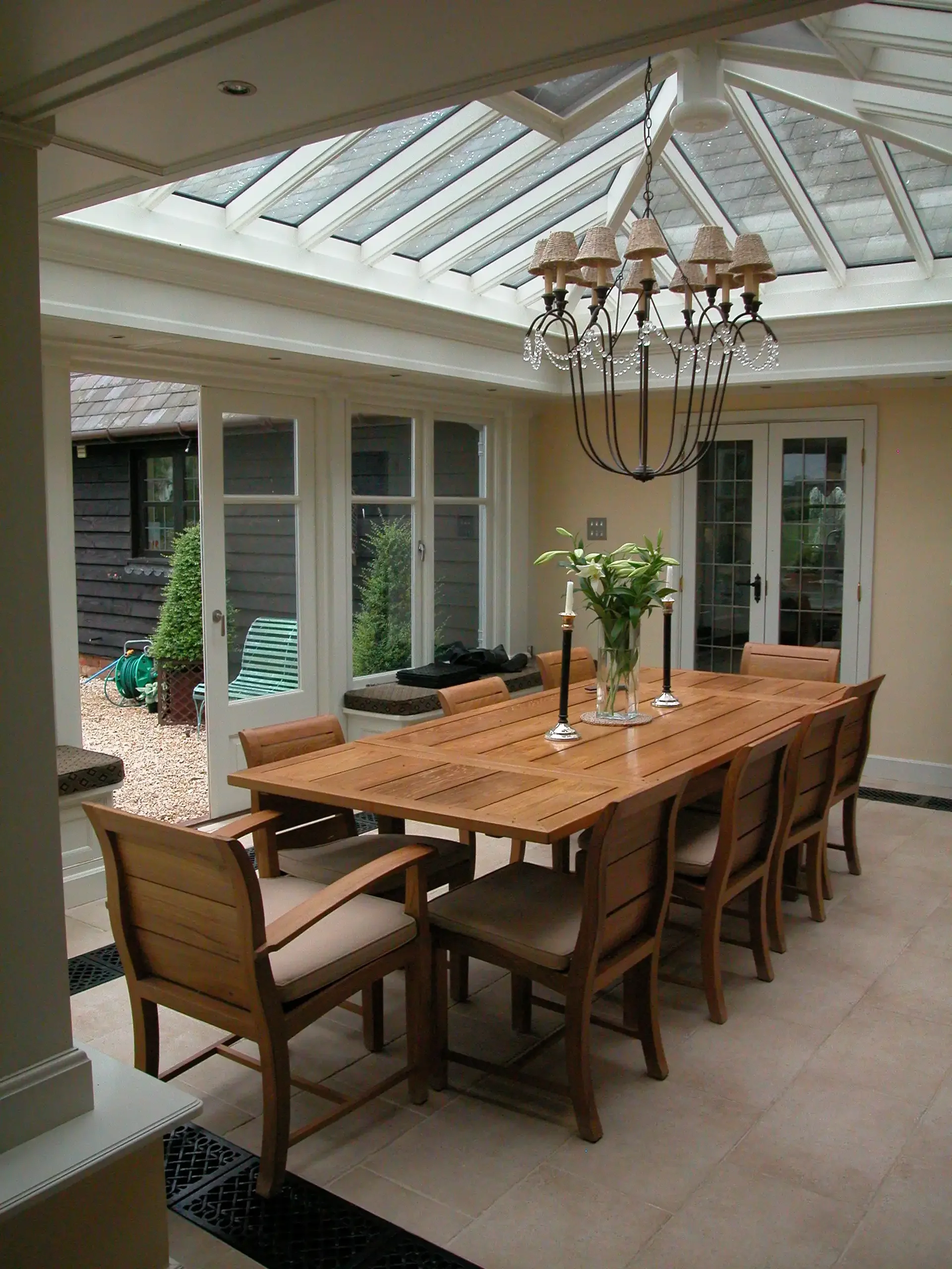 Light-filled interior of a bespoke wooden garden room extension featuring French doors opening directly to an outdoor terrace.