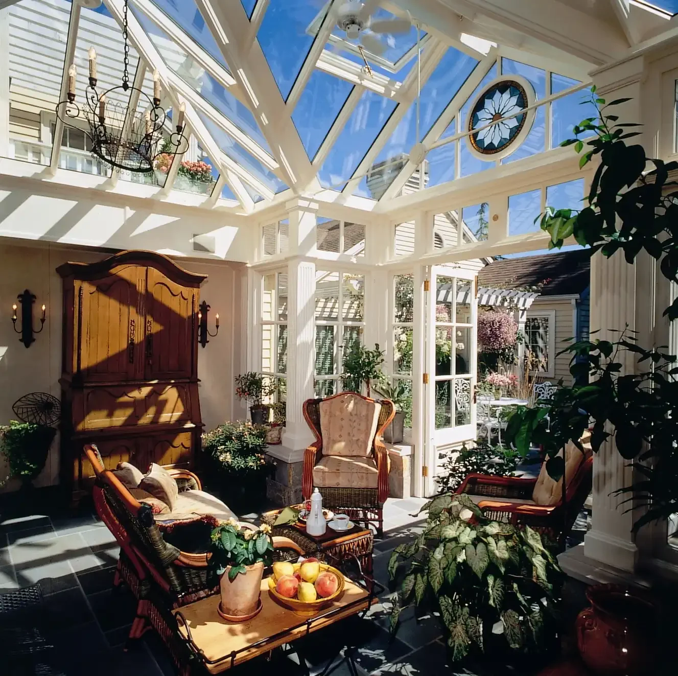 Bespoke white hardwood conservatory interior with a fully glazed pitched roof, decorative glazing and French doors opening onto the garden.