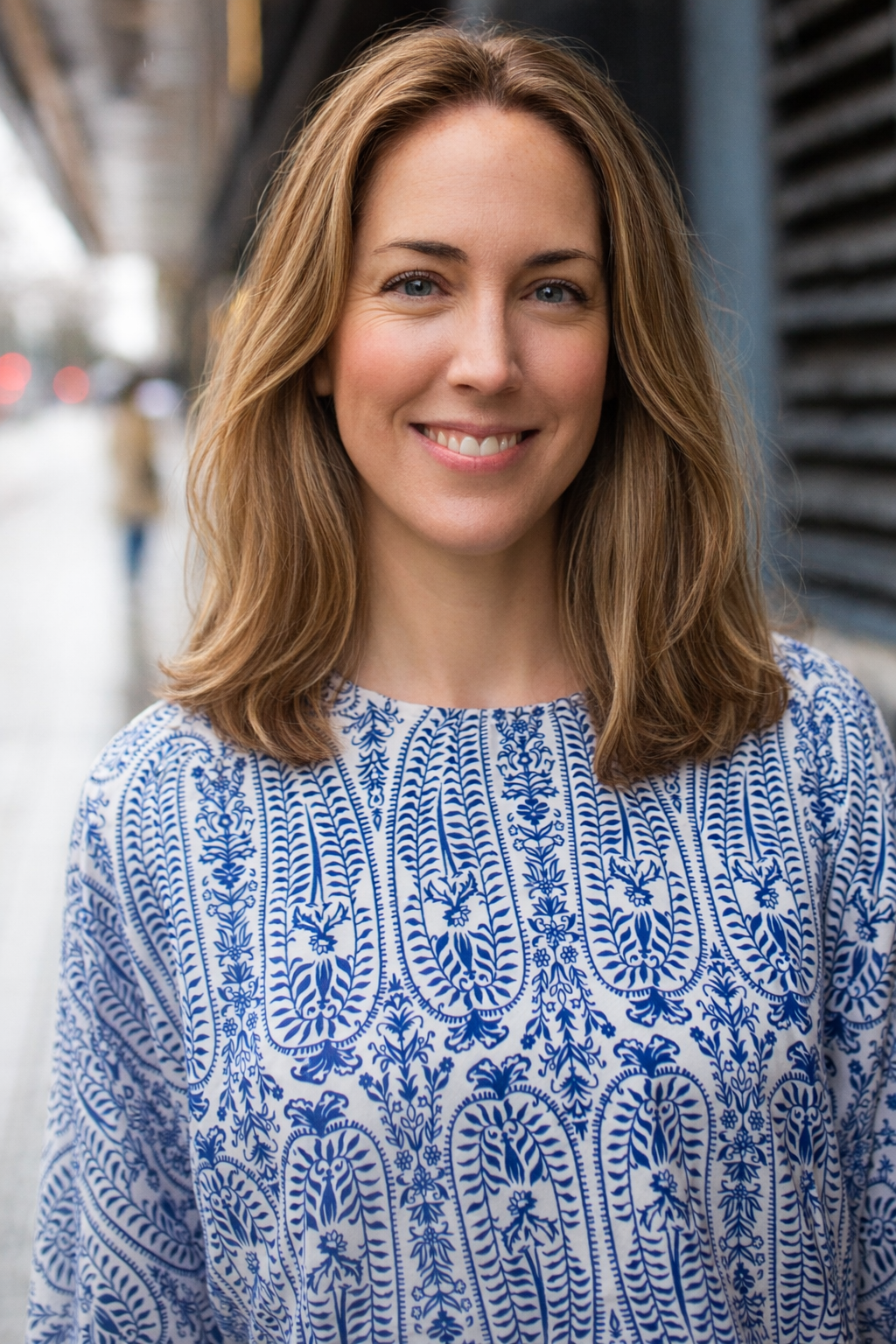 Dr. Caroline Connolly, Ivy League educator, University of Pennsylvania, Psychology Department, Positive Psychology. The Education Workspace. Higher Education. A smiling woman standing outdoors with blurred city street background.